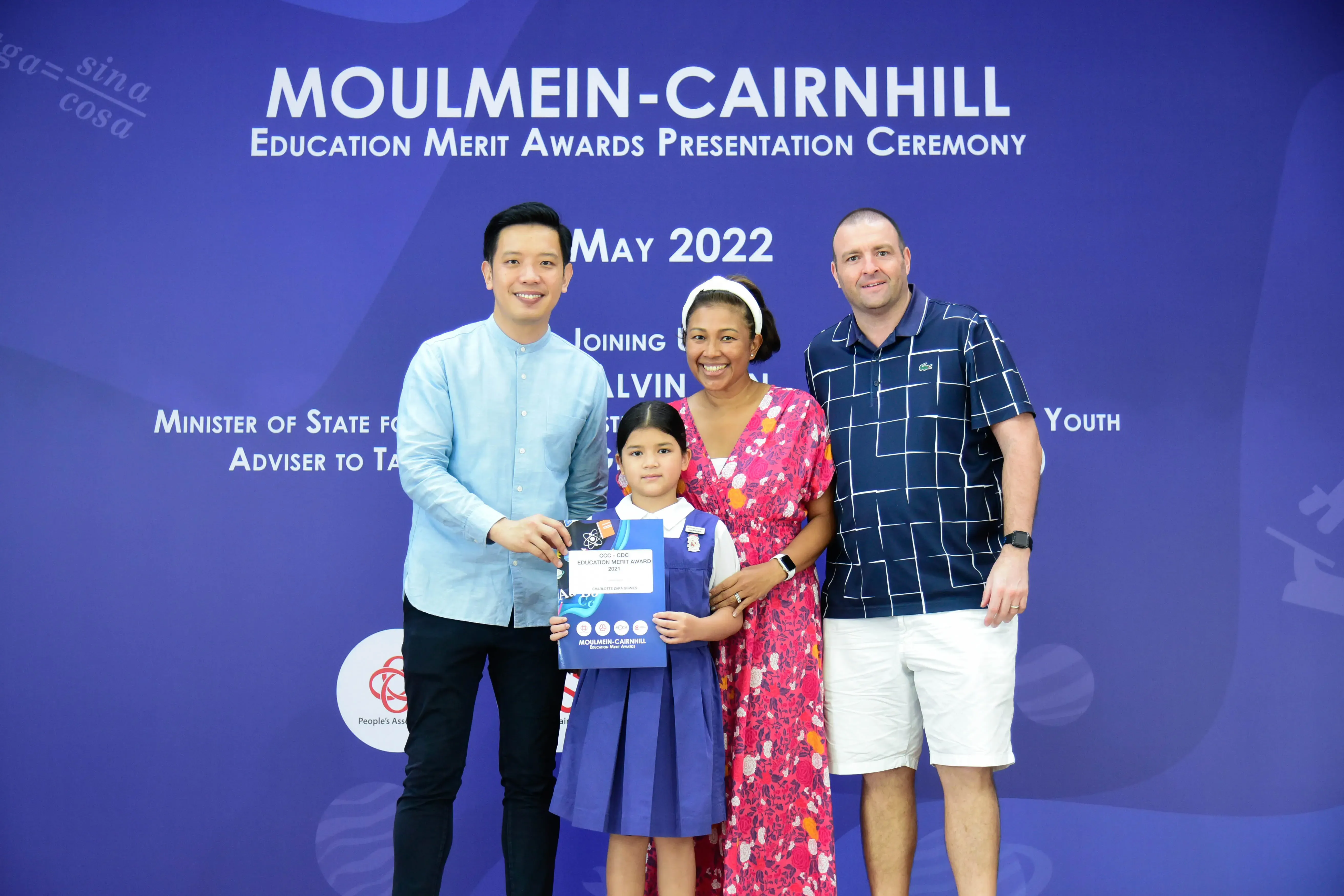 Three adults and a young girl pose at the Moulmein-Cairnhill Education Merit Awards Ceremony, May 2022.