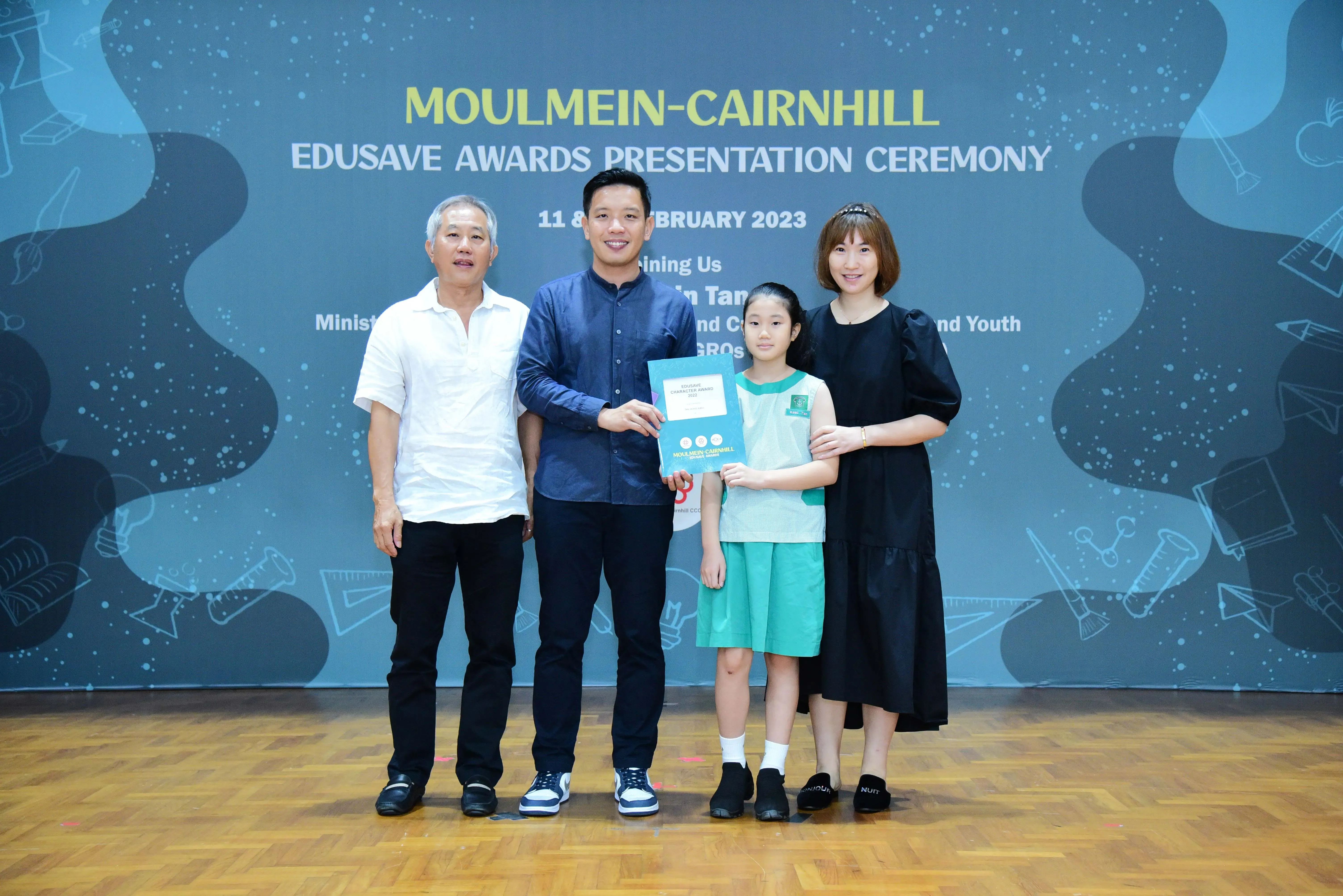 Four people pose with an award certificate at the Moulmein-Cairnhill Edusave Awards Presentation Ceremony 2023.
