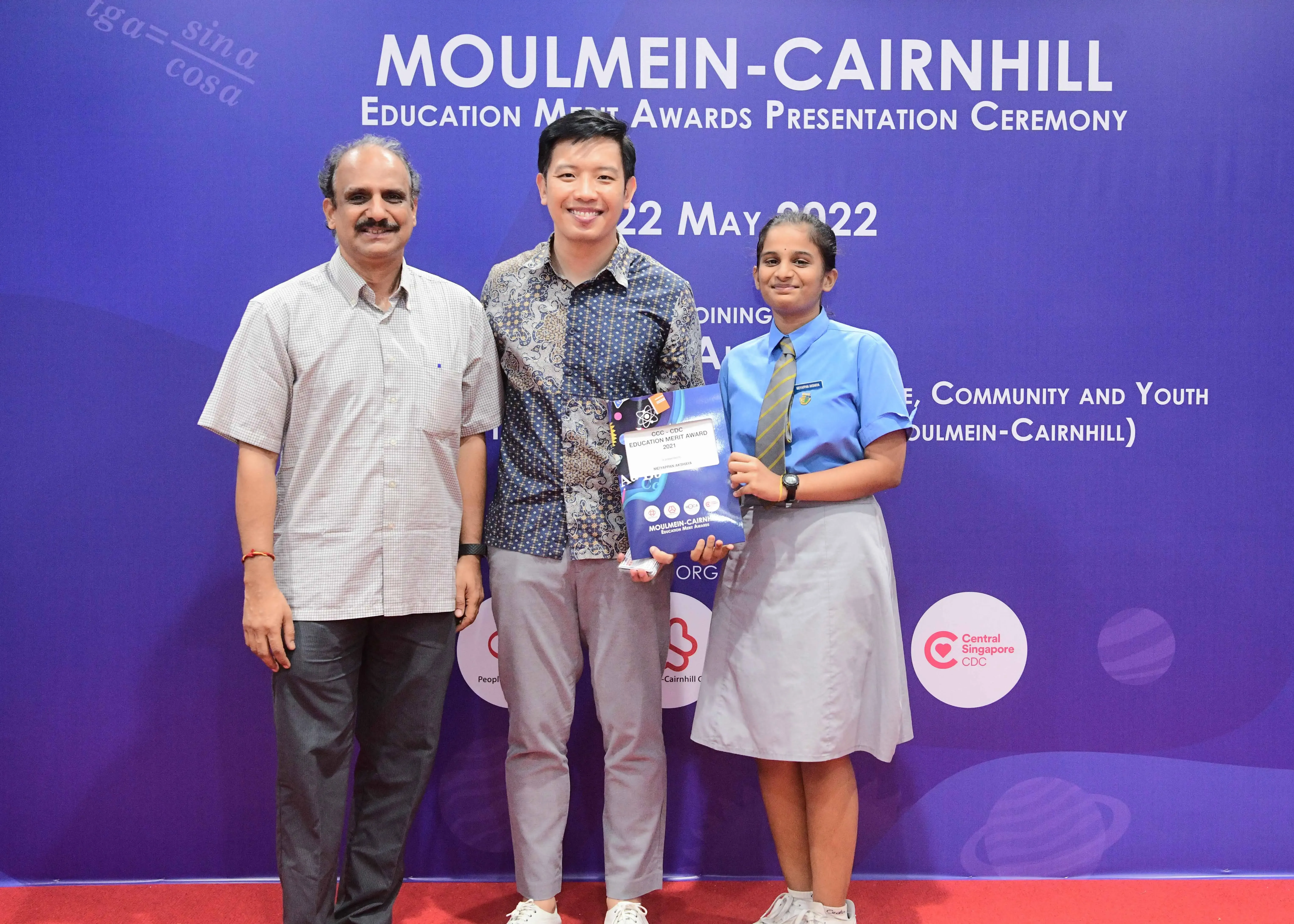 Three people posing at the Moulmein-Cairnhill Education Merit Awards Presentation Ceremony on 22 May 2022.
