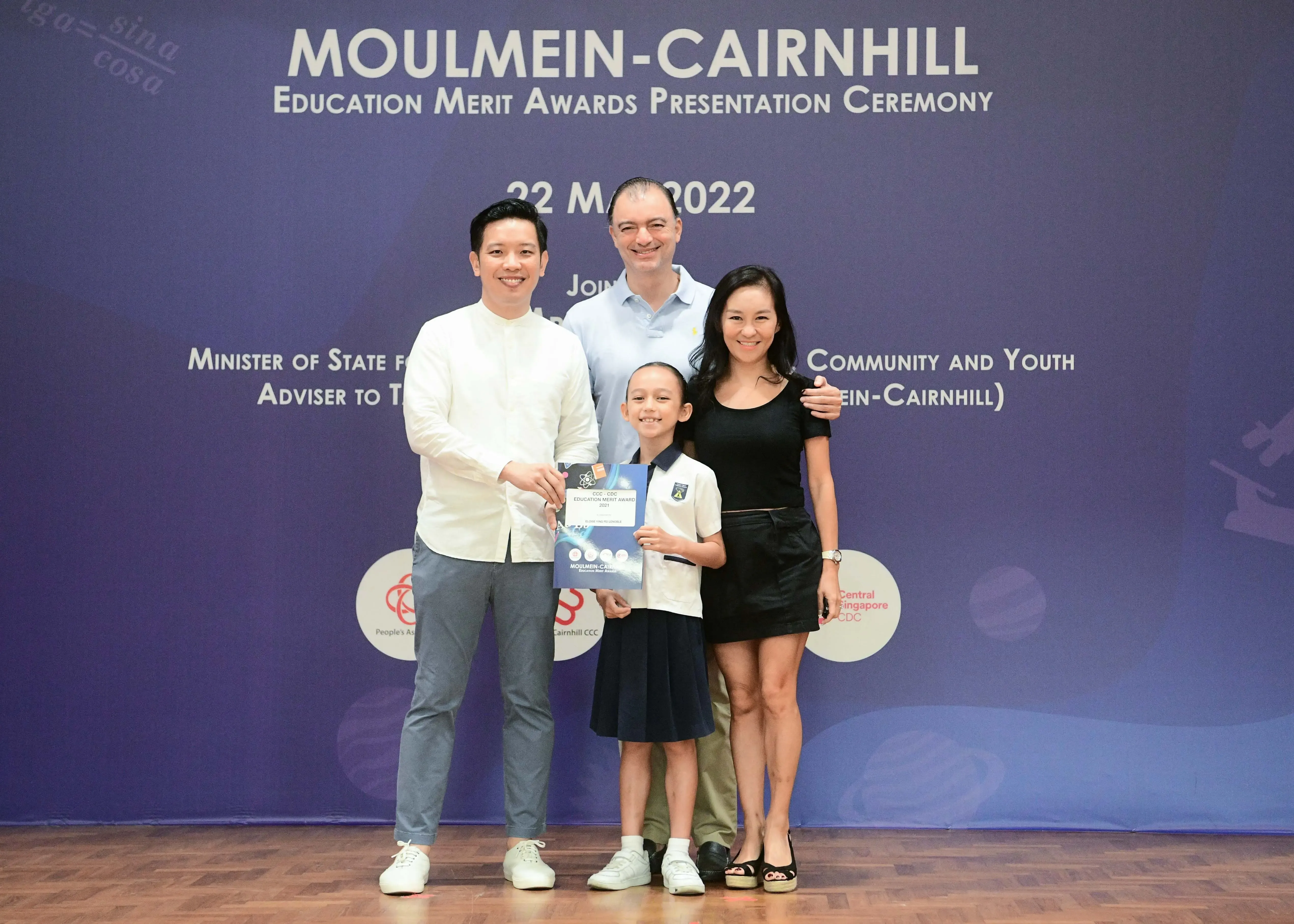 Three adults and a child pose at the Moulmein-Cairnhill Education Merit Awards Ceremony on 22 May 2022.