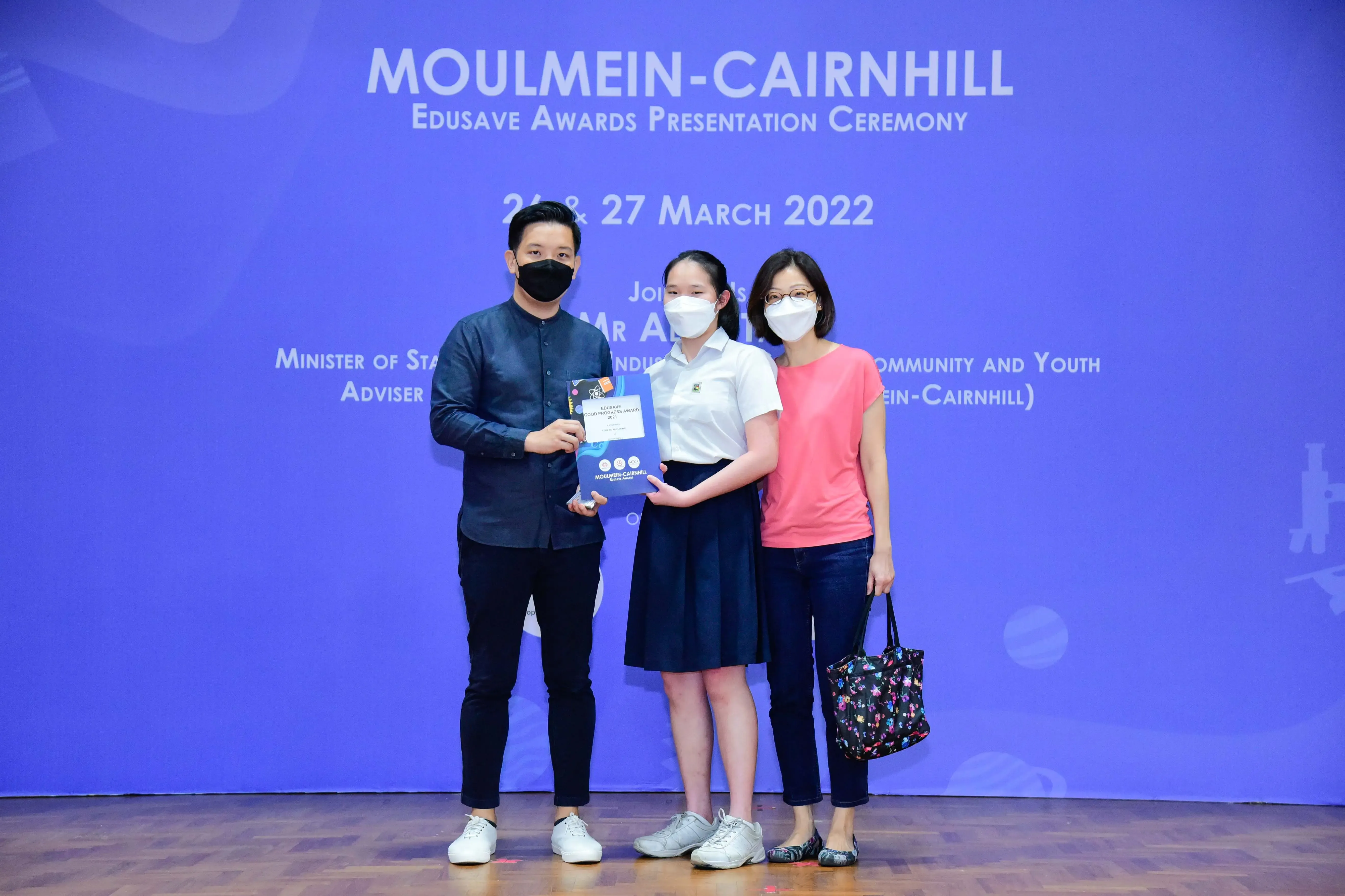 Three masked people pose at the Moulmein-Cairnhill Edusave Awards Presentation Ceremony on 27 March 2022.