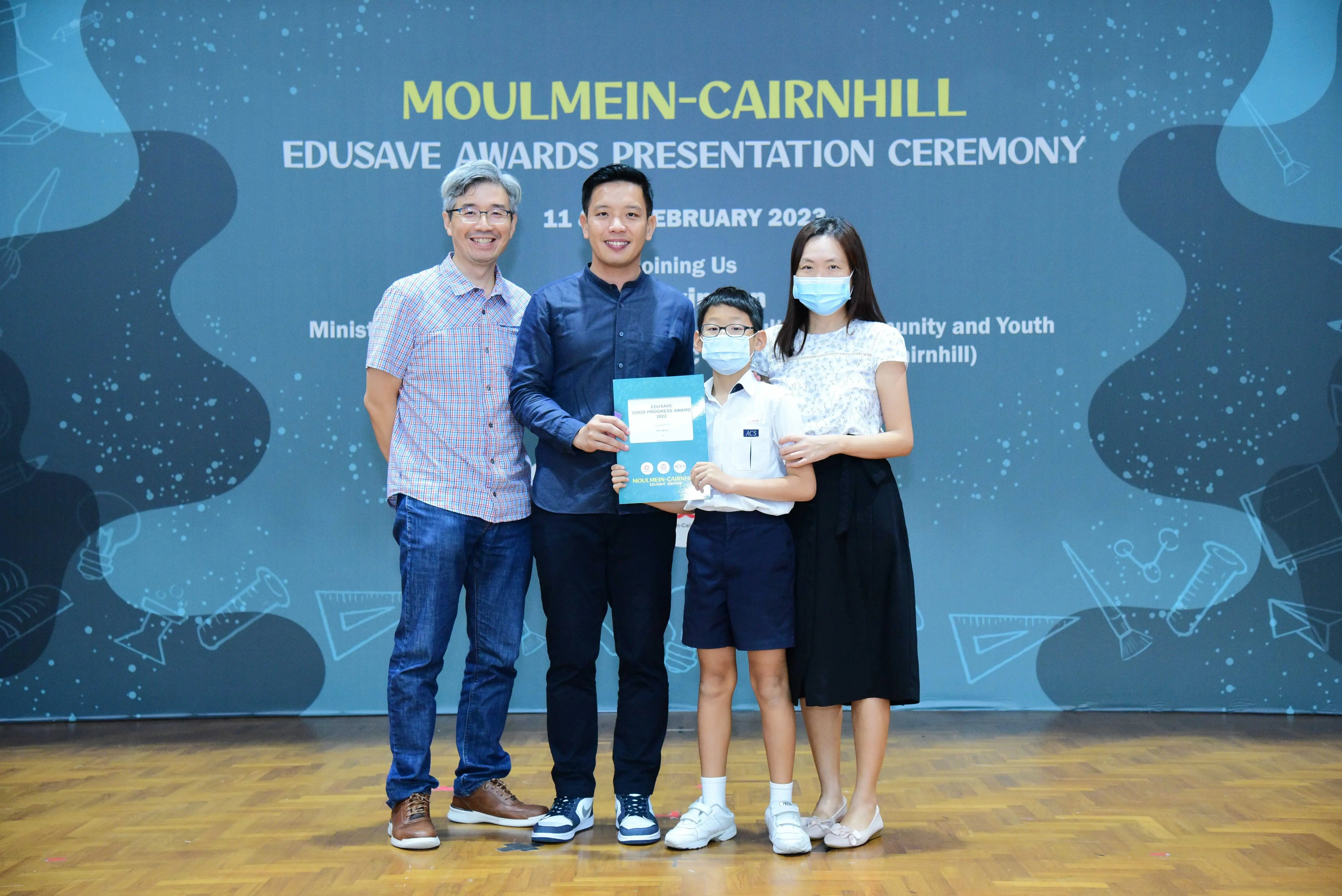 Four people pose with a certificate at the Moulmein-Cairnhill Edusave Awards Presentation Ceremony in February 2023.