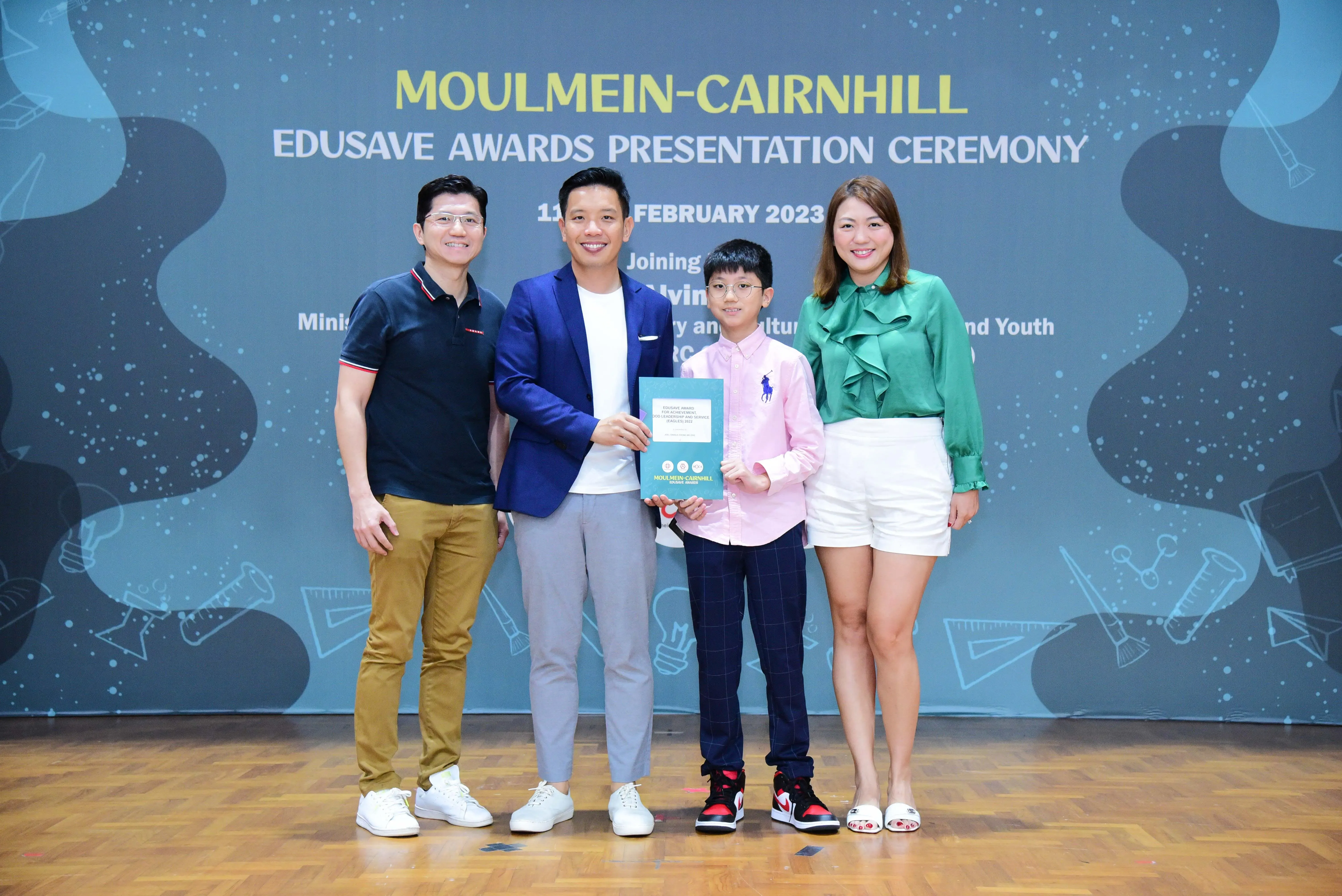 Four people pose at the Moulmein-Cairnhill Edusave Awards Presentation Ceremony in February 2023.