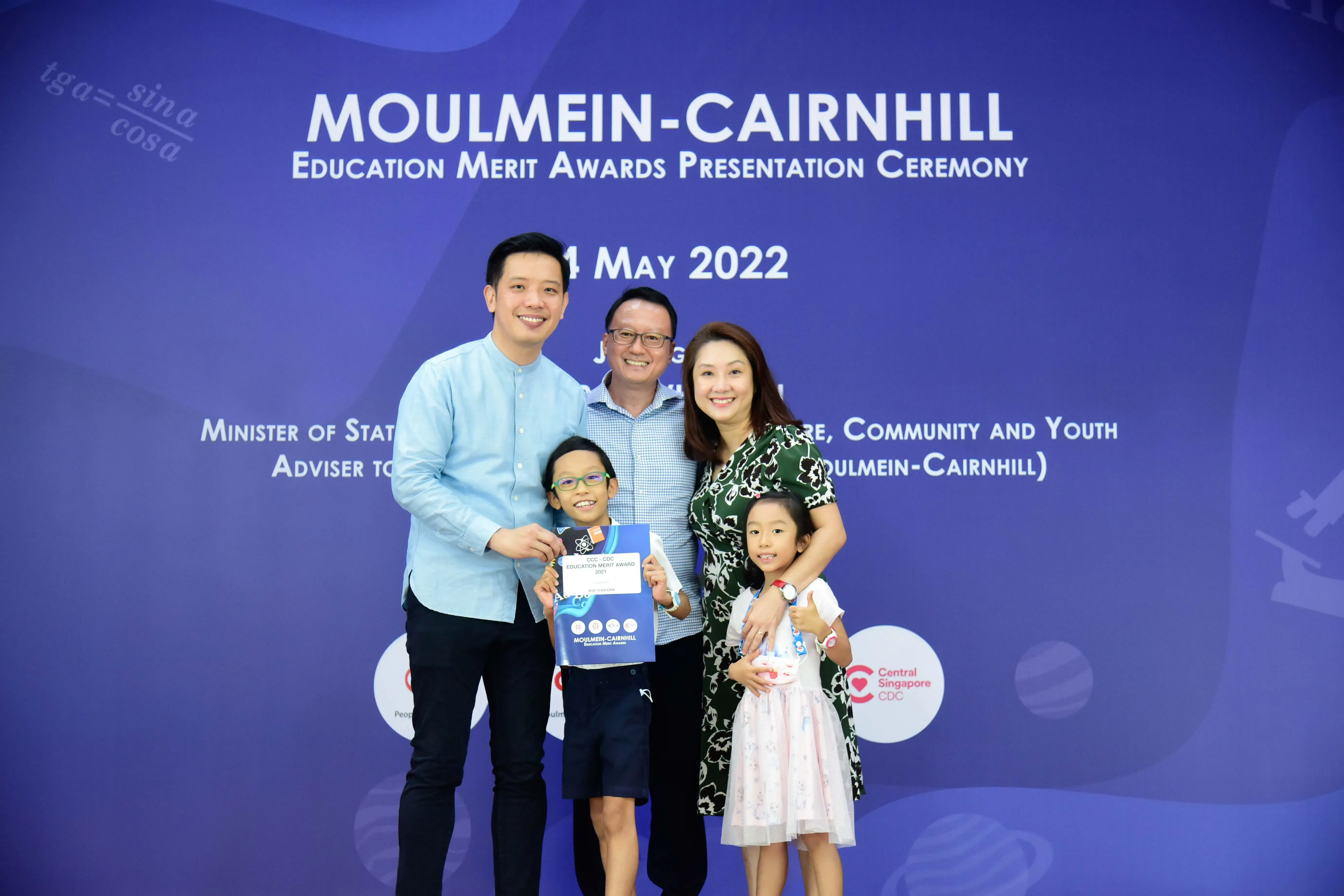 Four adults and two children pose at the Moulmein-Cairnhill Education Merit Awards ceremony on 4 May 2022.
