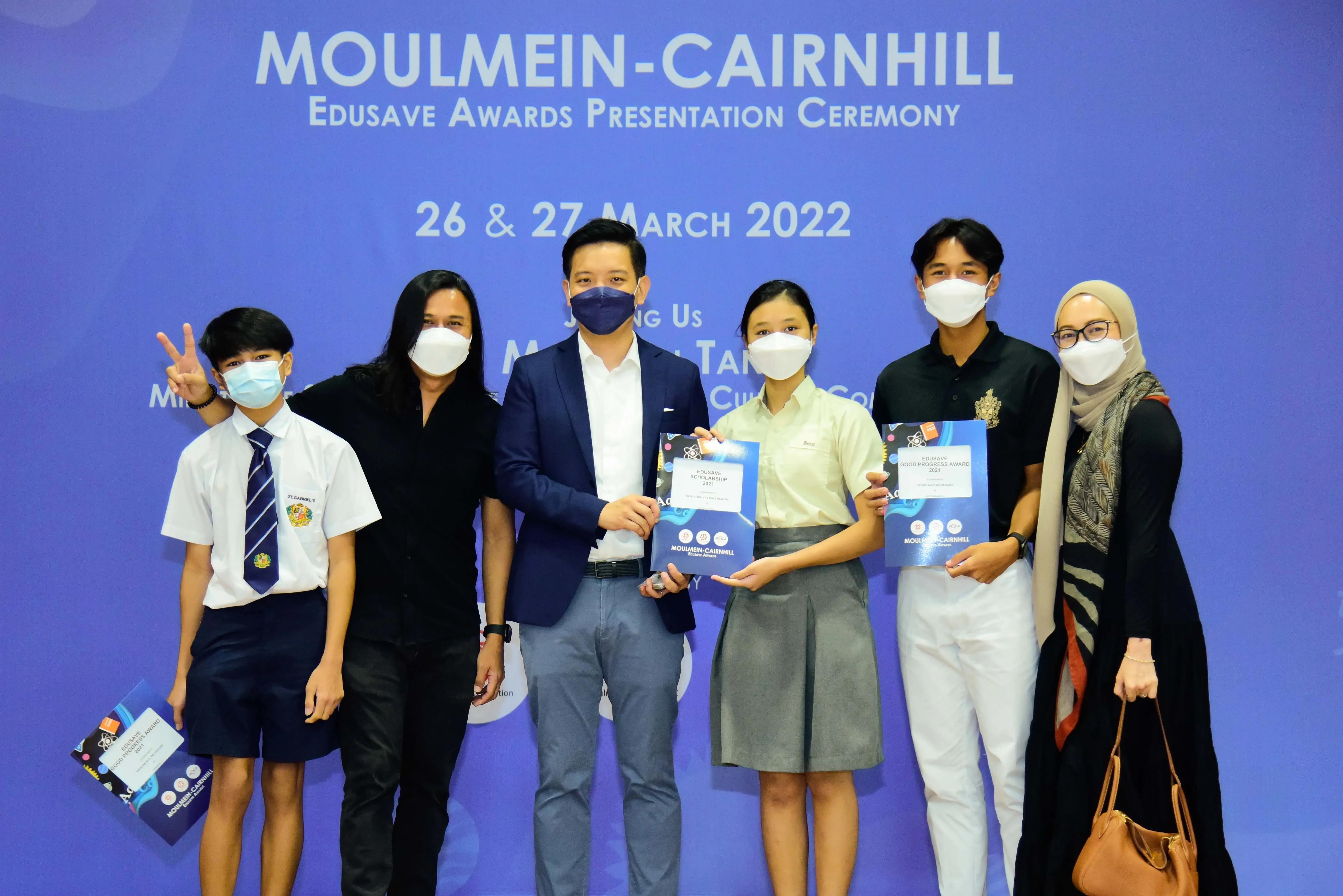 Six masked people pose at the Moulmein-Cairnhill Edusave Awards Presentation Ceremony on 26-27 March 2022.