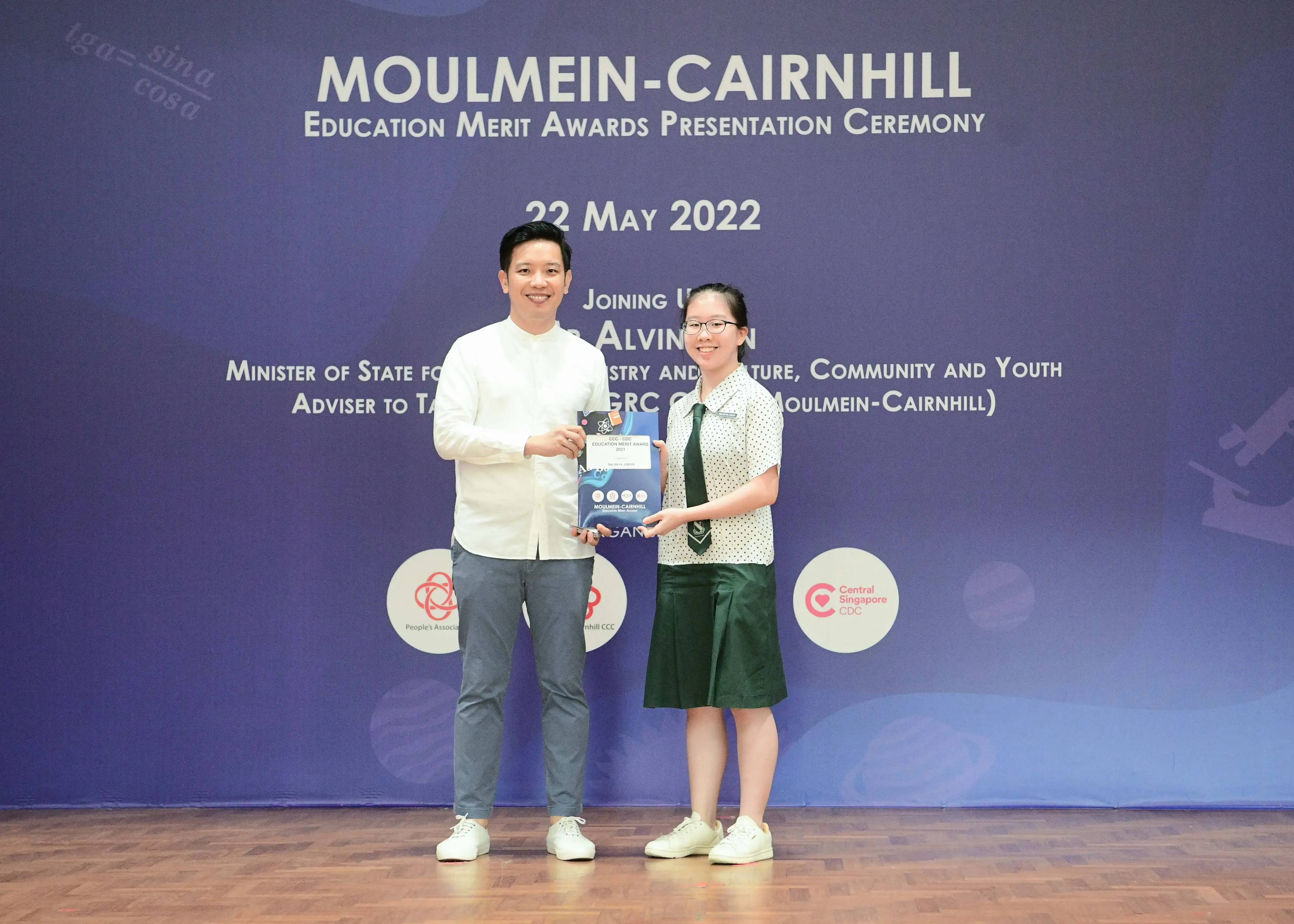 Two people holding an award certificate at the Moulmein-Cairnhill Education Merit Awards Presentation Ceremony, 22 May 2022.