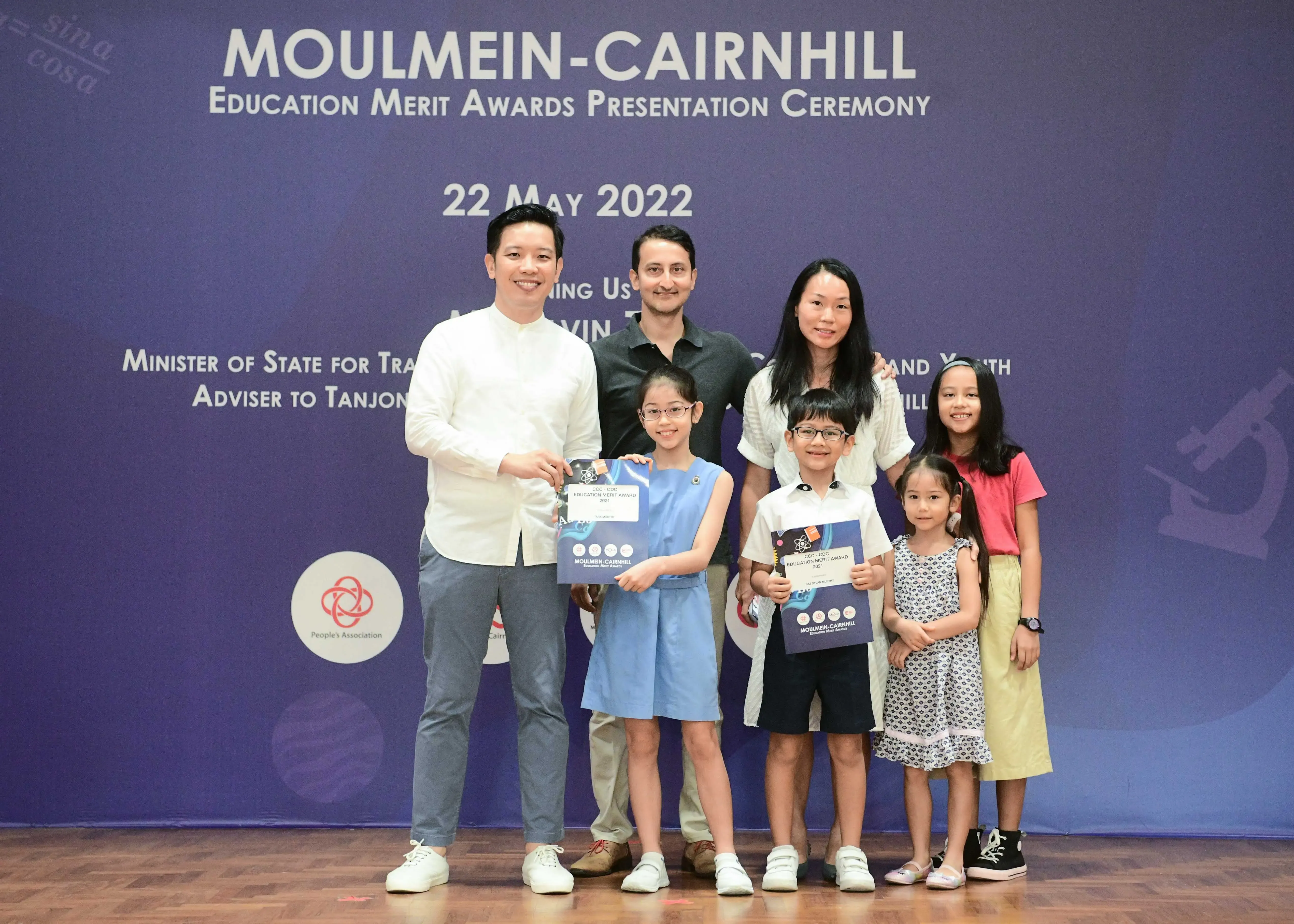 Adults and children pose with award certificates at the Moulmein-Cairnhill Education Merit Awards ceremony on 22 May 2022.