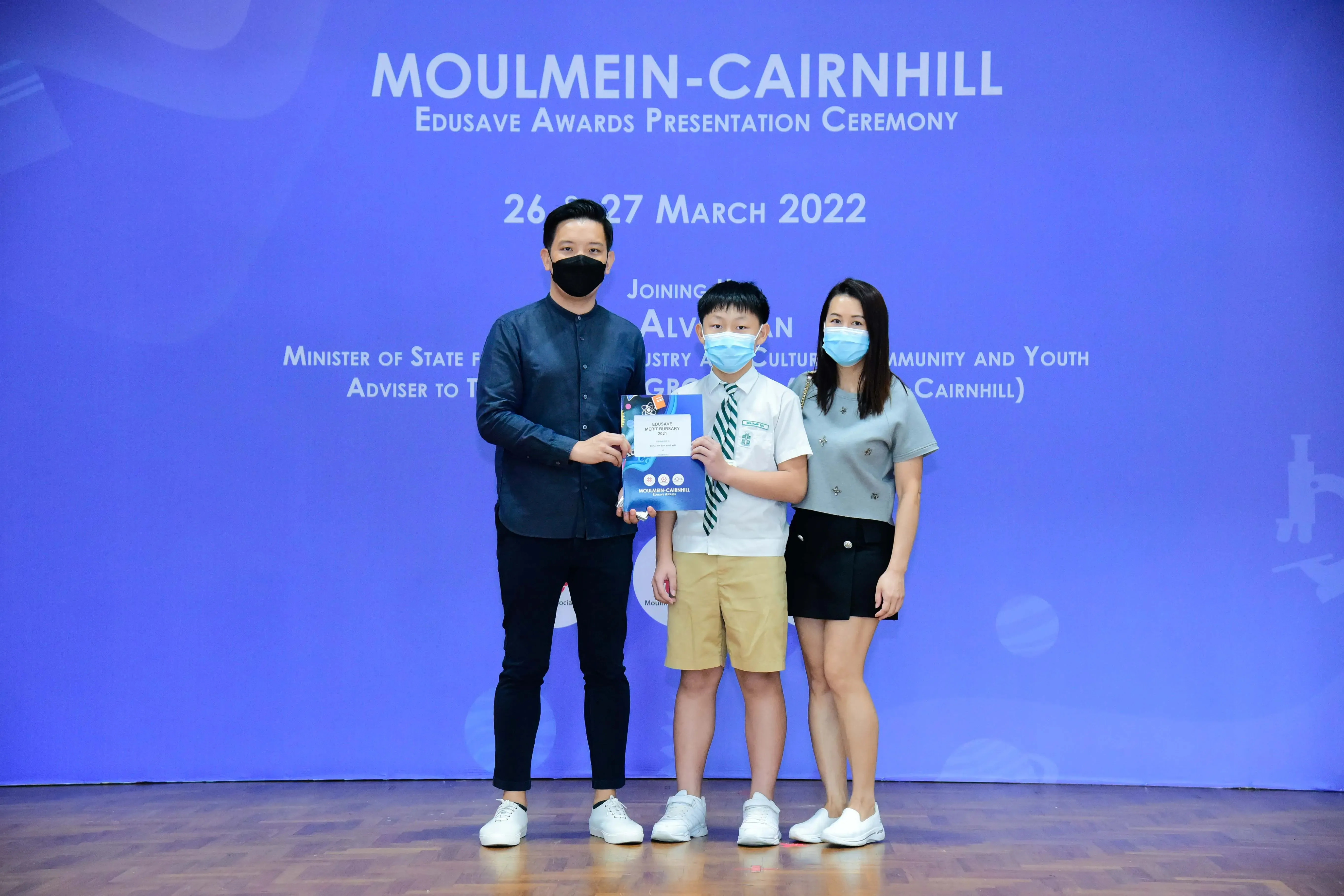 Three masked people pose at the Moulmein-Cairnhill Edusave Awards Ceremony on 26-27 March 2022.
