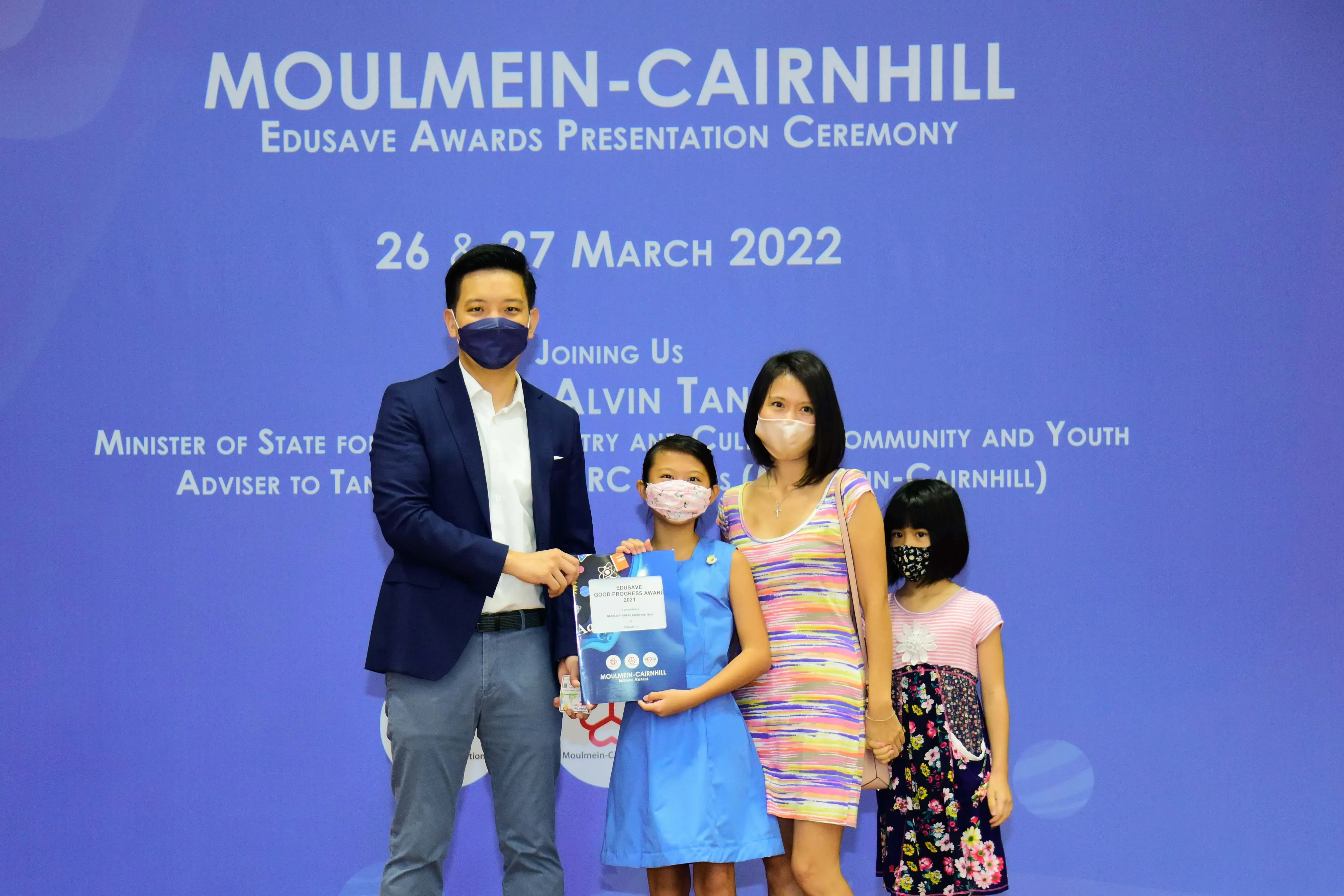 Four masked people pose at the Moulmein-Cairnhill Edusave Awards Ceremony on 26-27 March 2022.