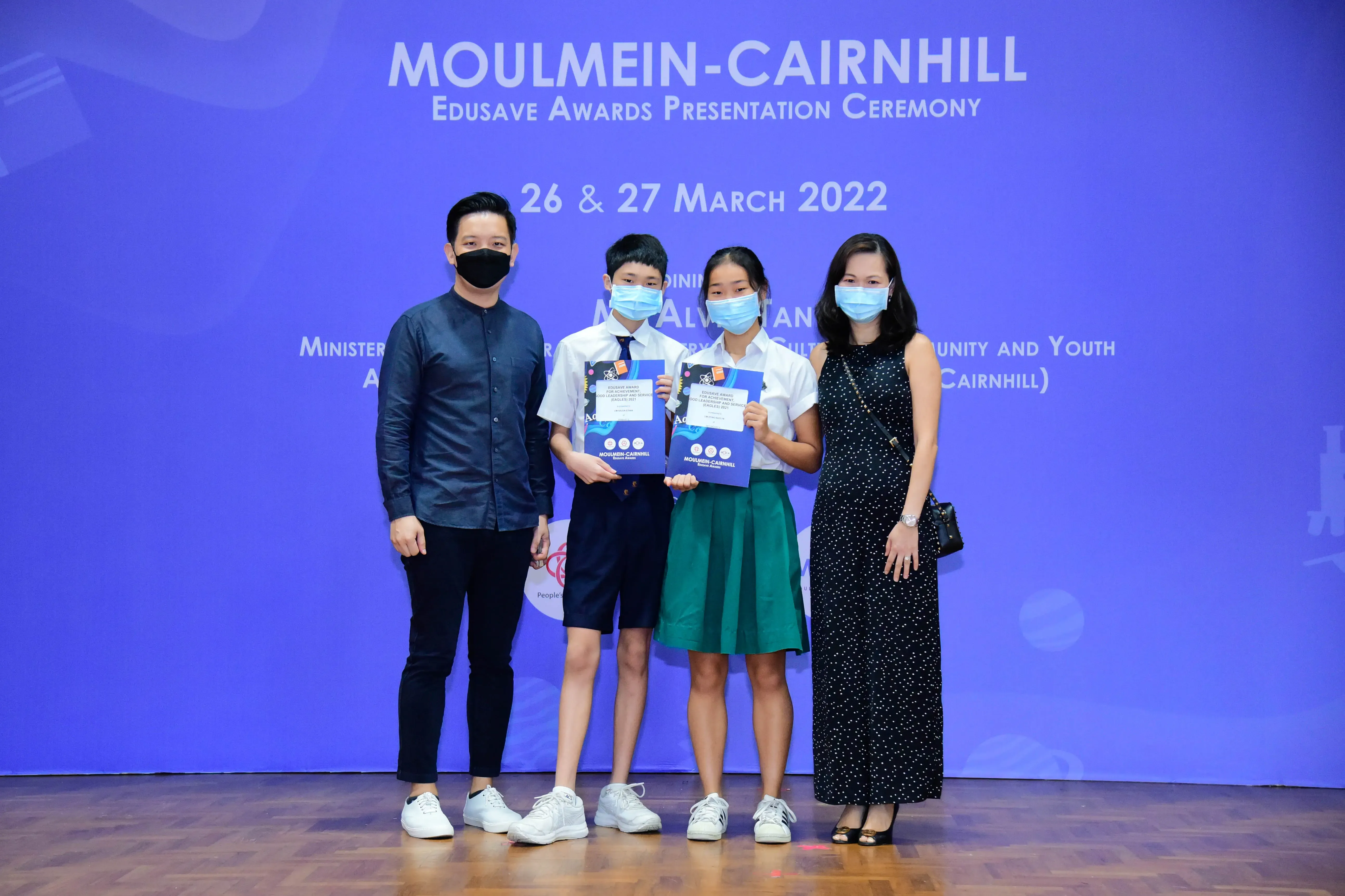Four masked people pose at the Moulmein-Cairnhill Edusave Awards Ceremony on 26 & 27 March 2022.