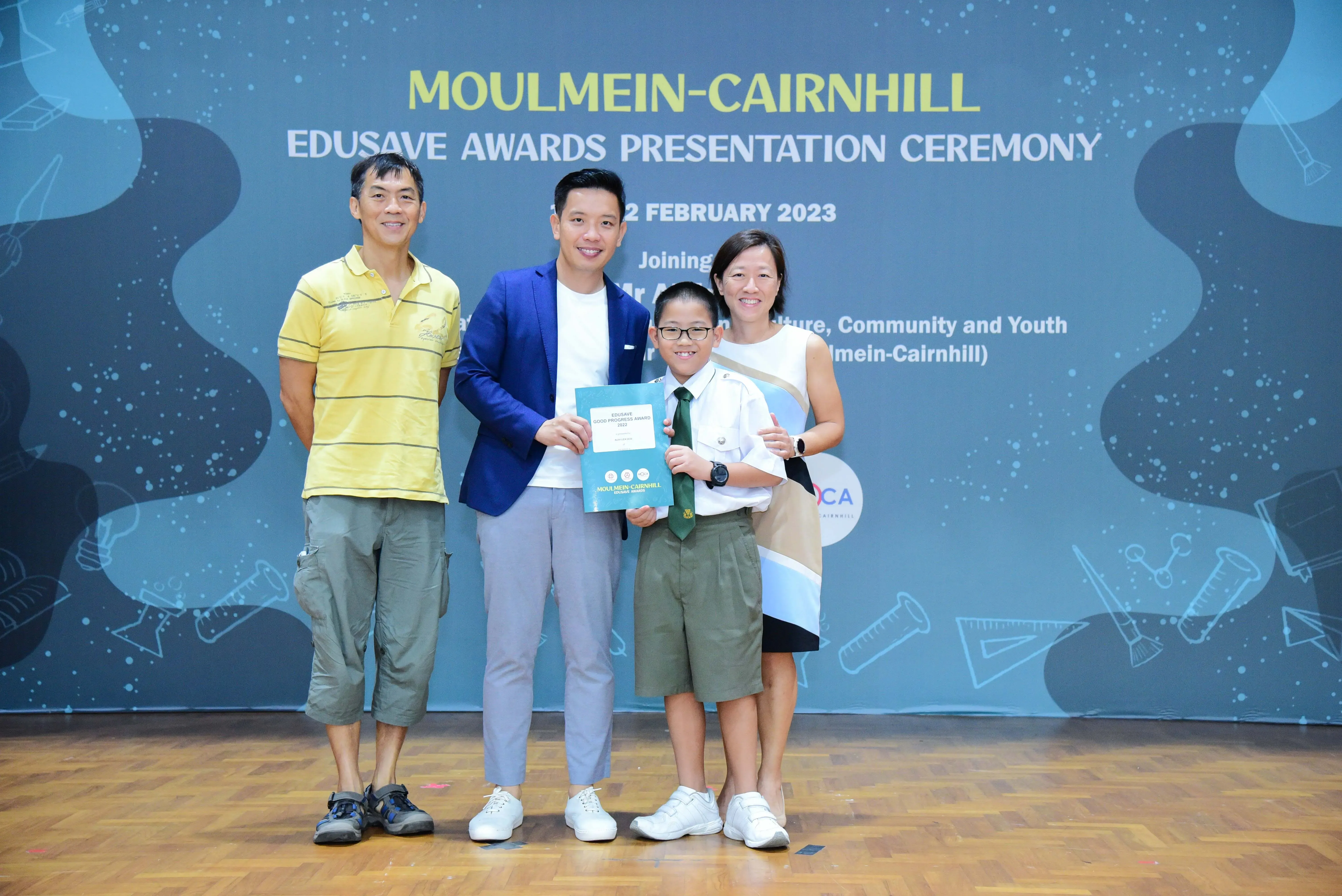 Four people pose with a certificate at the Moulmein-Cairnhill Edusave Awards Presentation Ceremony on 2 February 2023.