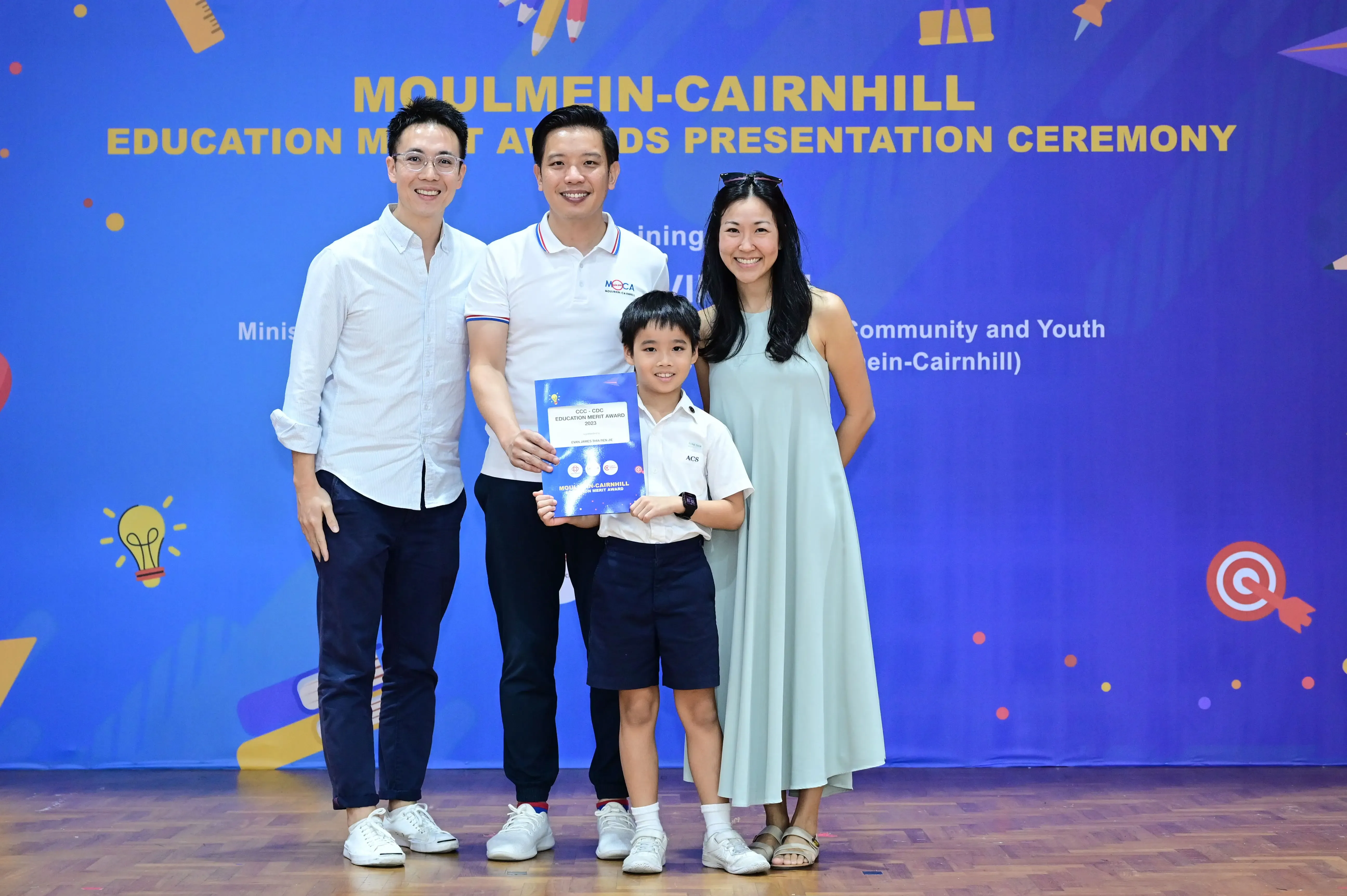 Three adults and a boy holding an award certificate pose at the Moulmein-Cairnhill Education Merit Awards Presentation Ceremony.