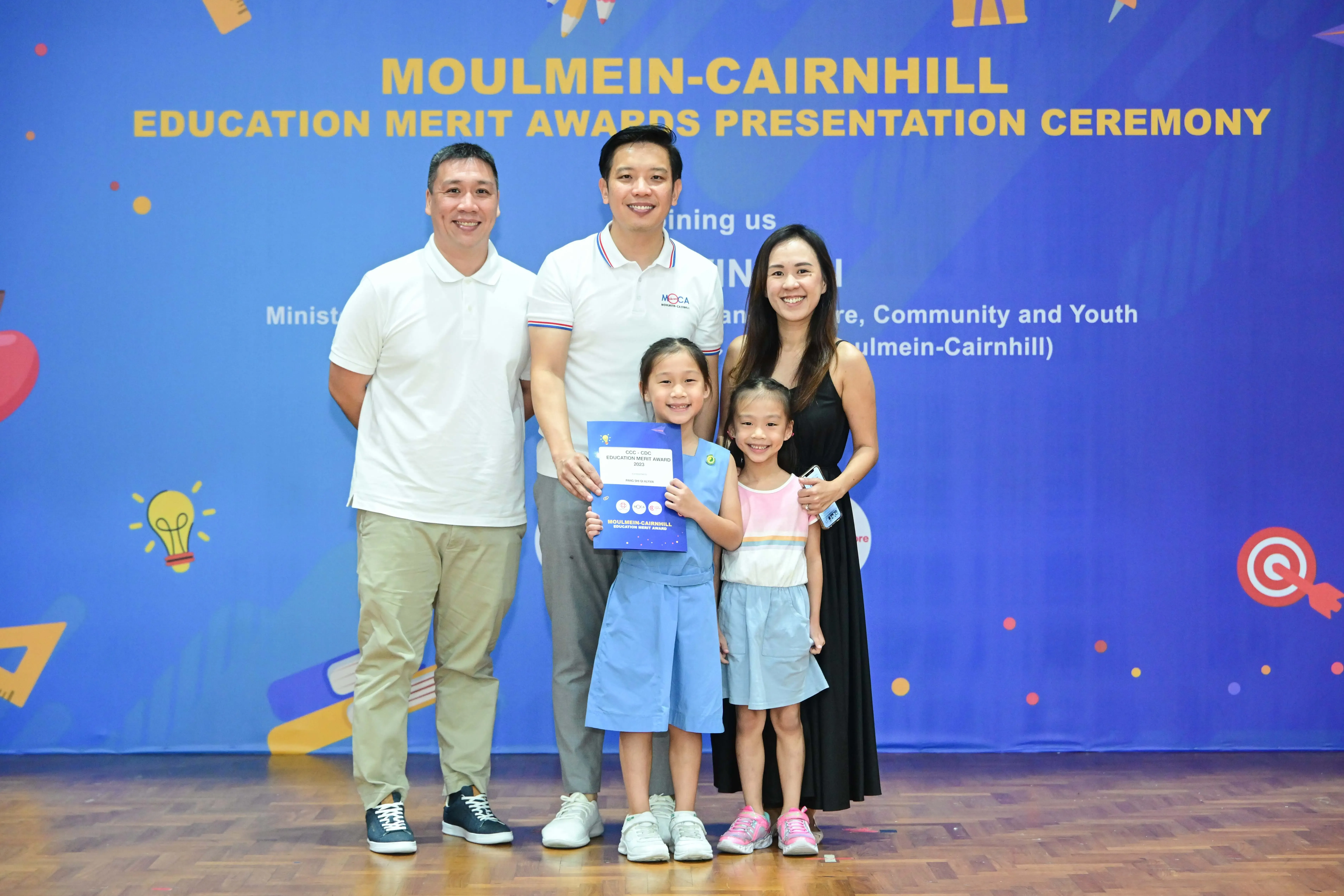 Two men, a woman, and two young girls pose at the Moulmein-Cairnhill Education Merit Awards Presentation Ceremony.