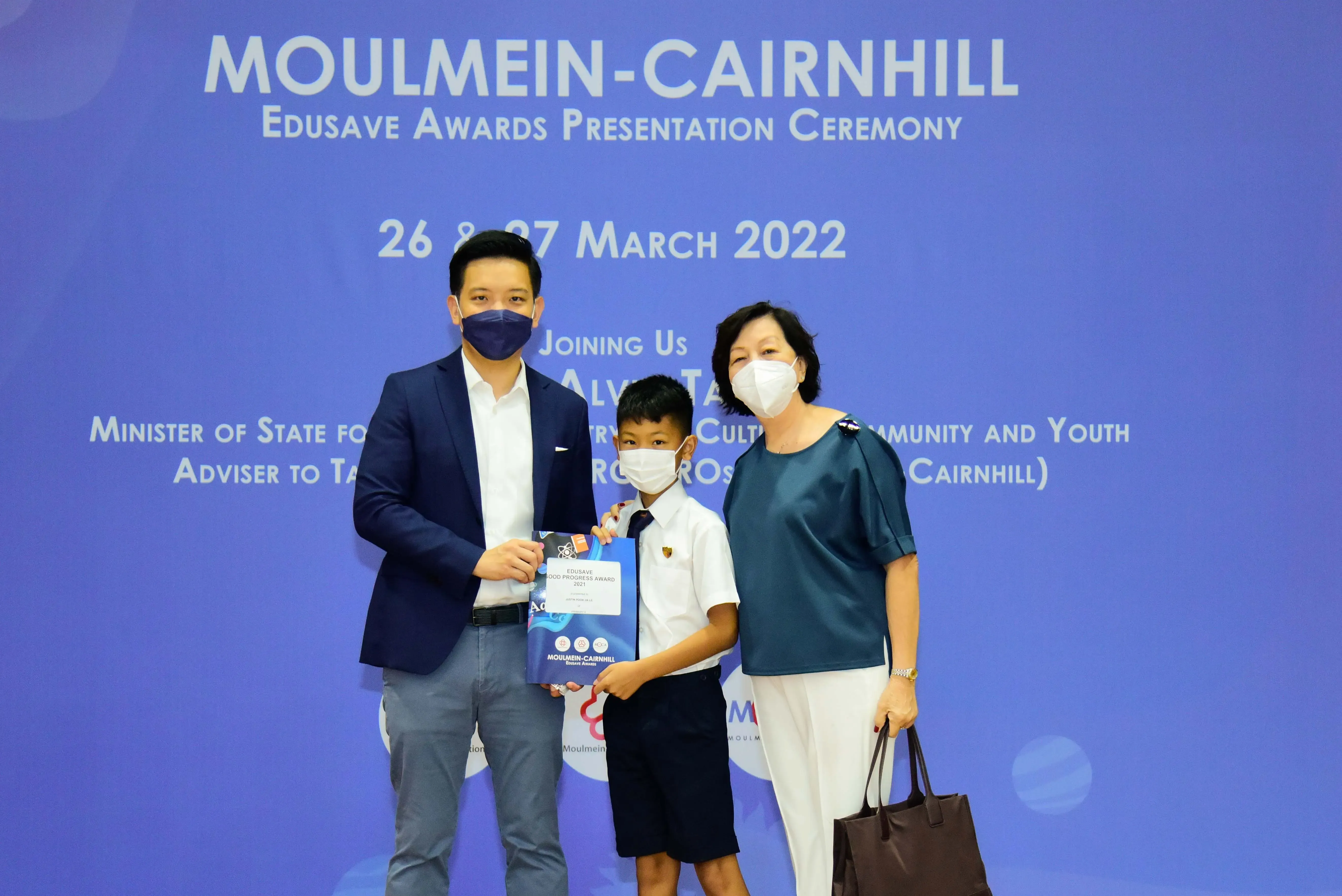 Three masked people pose at the Moulmein-Cairnhill Edusave Awards Presentation Ceremony on 26-27 March 2022.