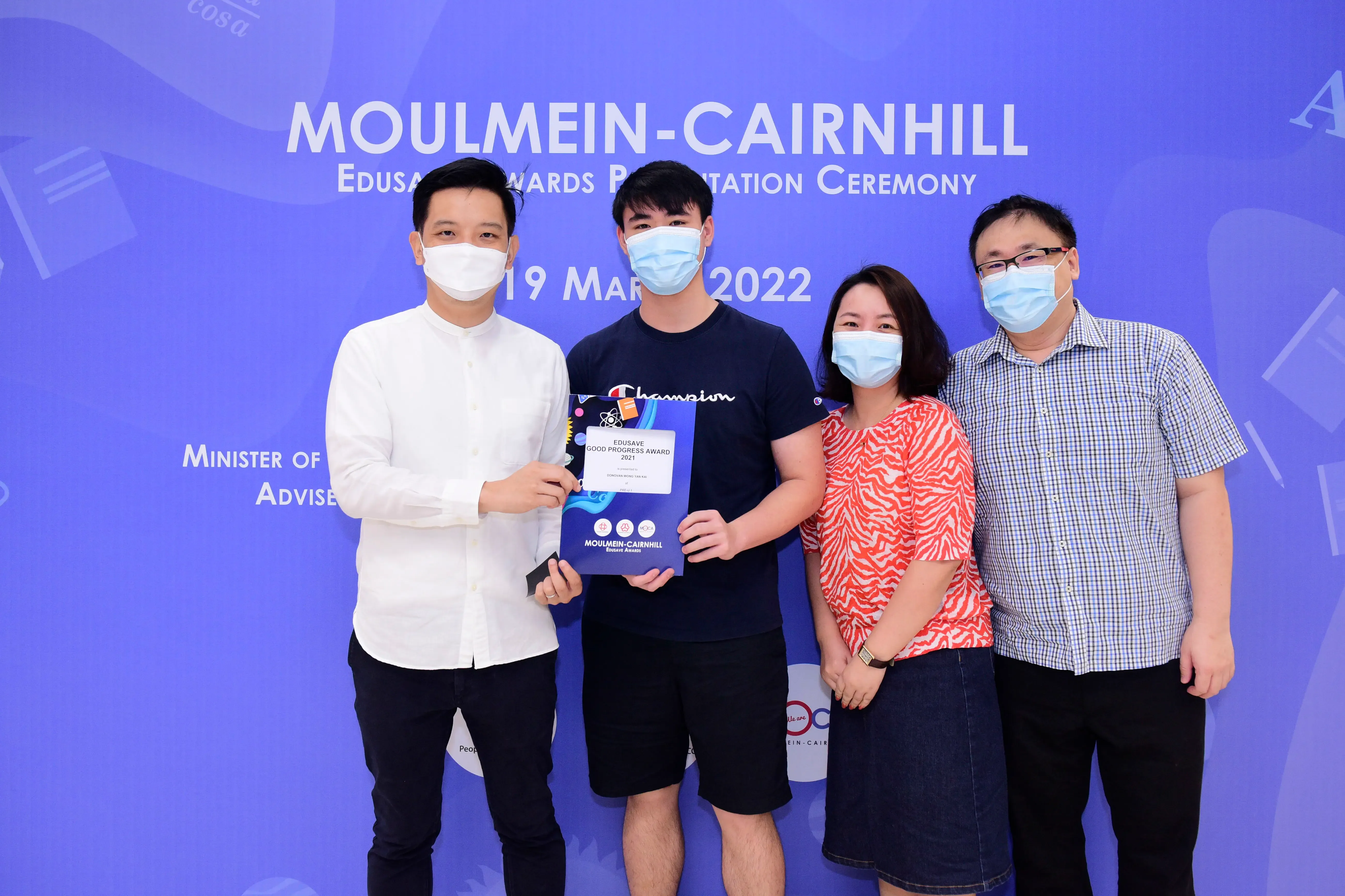 Four masked people pose at the Moulmein-Cairnhill Edusave Awards Presentation Ceremony on 19 March 2022.
