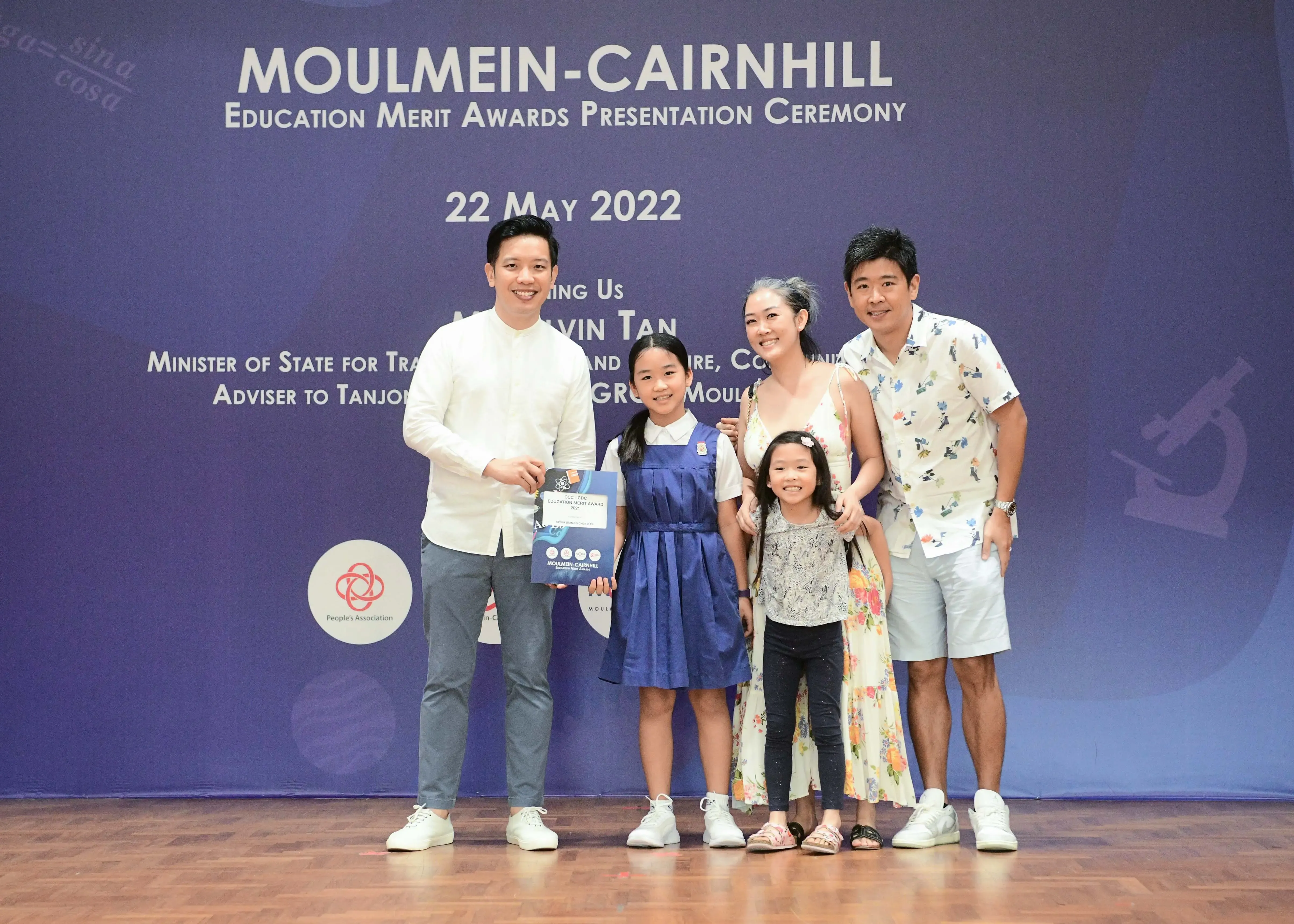 Five people pose on a stage at the Moulmein-Cairnhill Education Merit Awards Ceremony on 22 May 2022.
