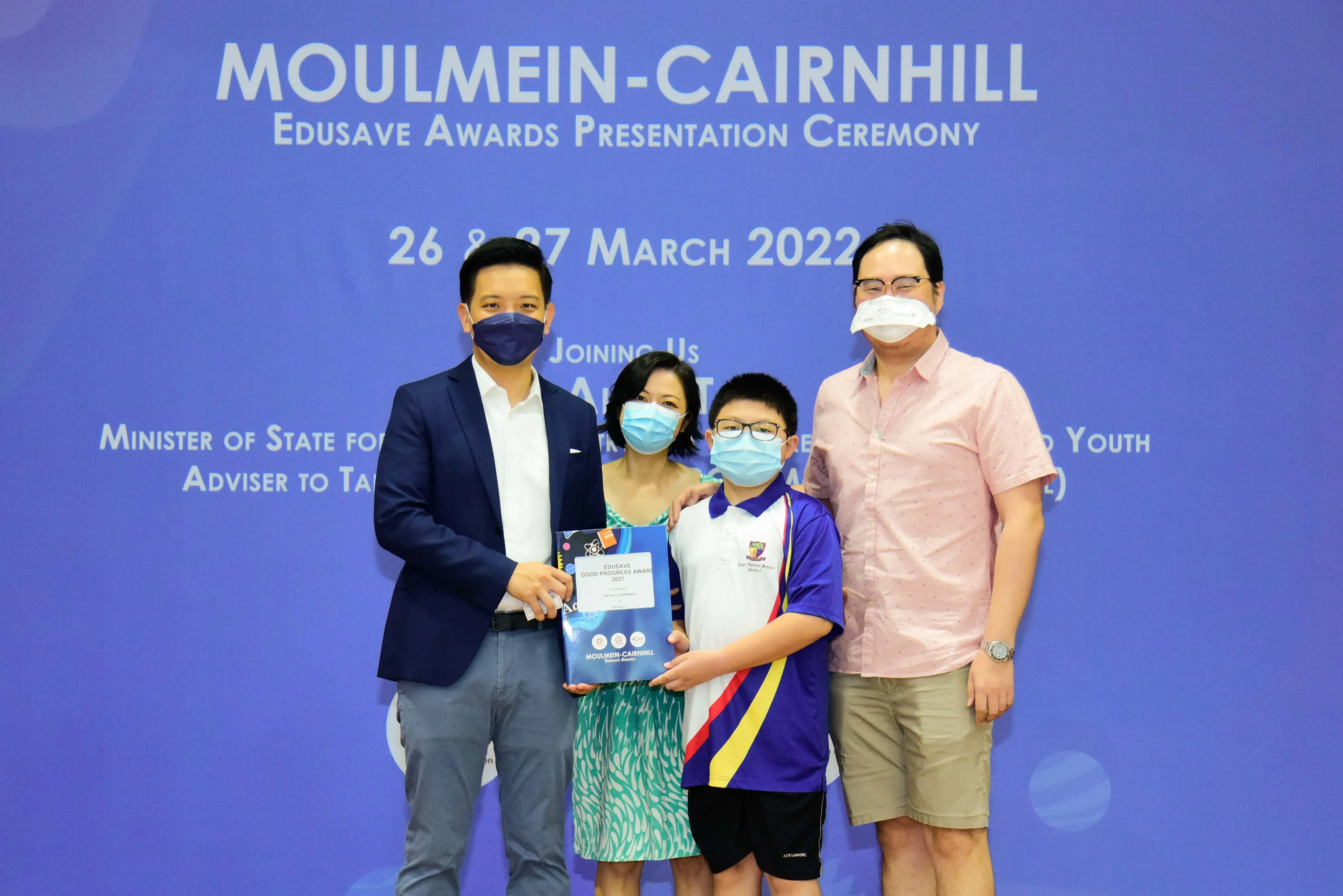 Four masked people pose at the Moulmein-Cairnhill Edusave Awards Presentation Ceremony on 26-27 March 2022.