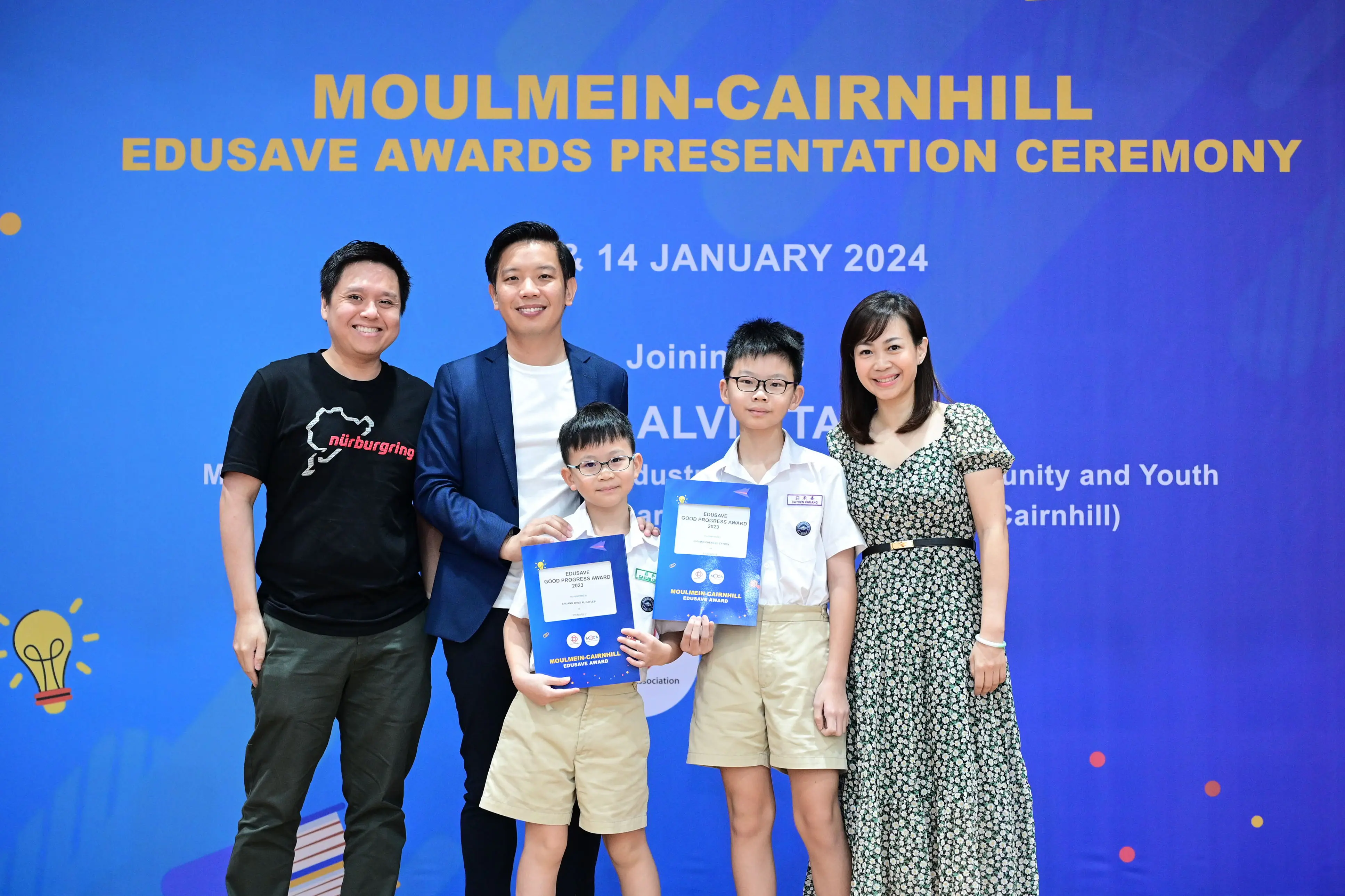 Three adults and two boys holding award certificates pose at the Moulmein-Cairnhill Edusave Awards Ceremony, January 2024.