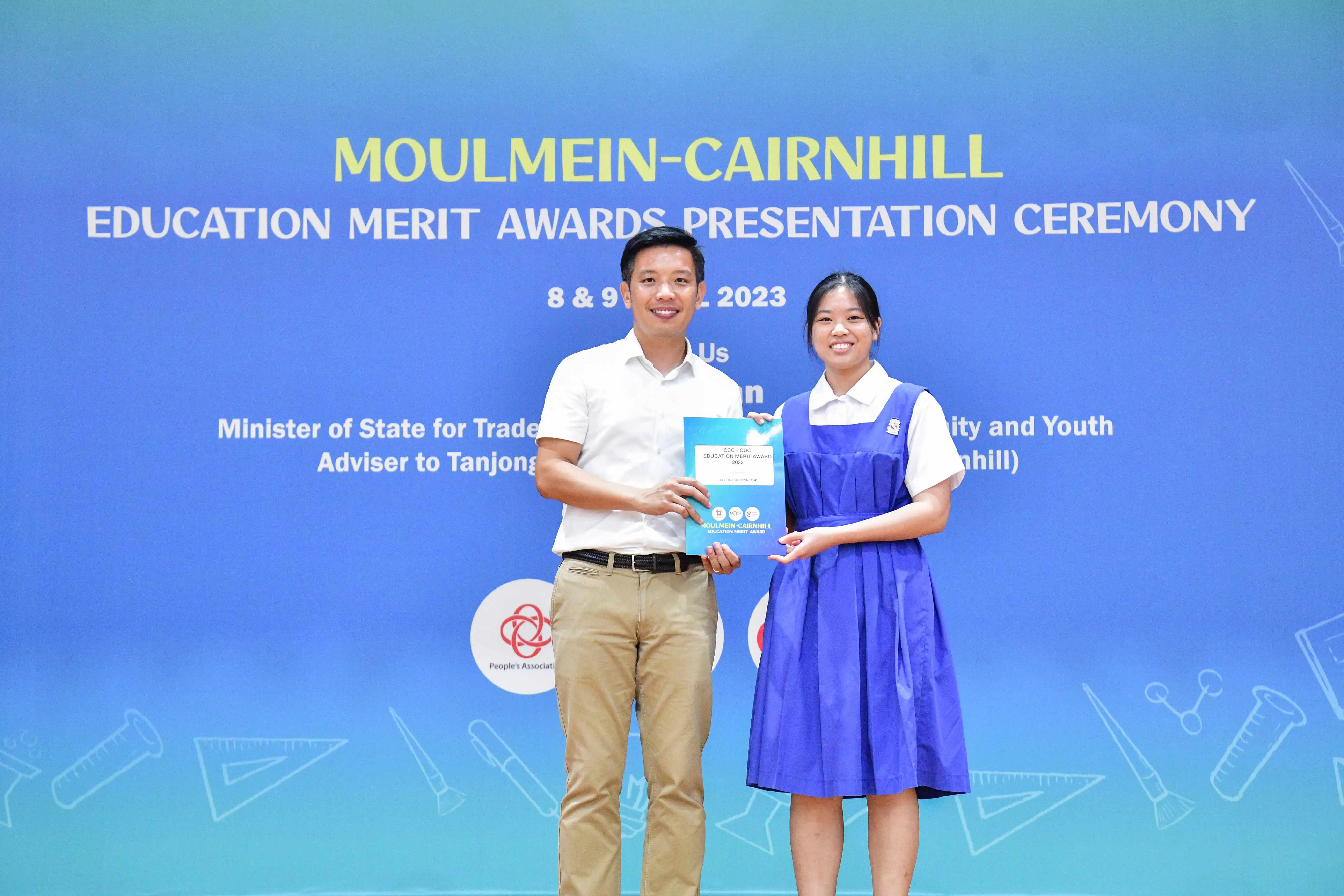 A man and a girl in school uniform hold an award certificate at the Moulmein-Cairnhill Education Merit Awards 2023.