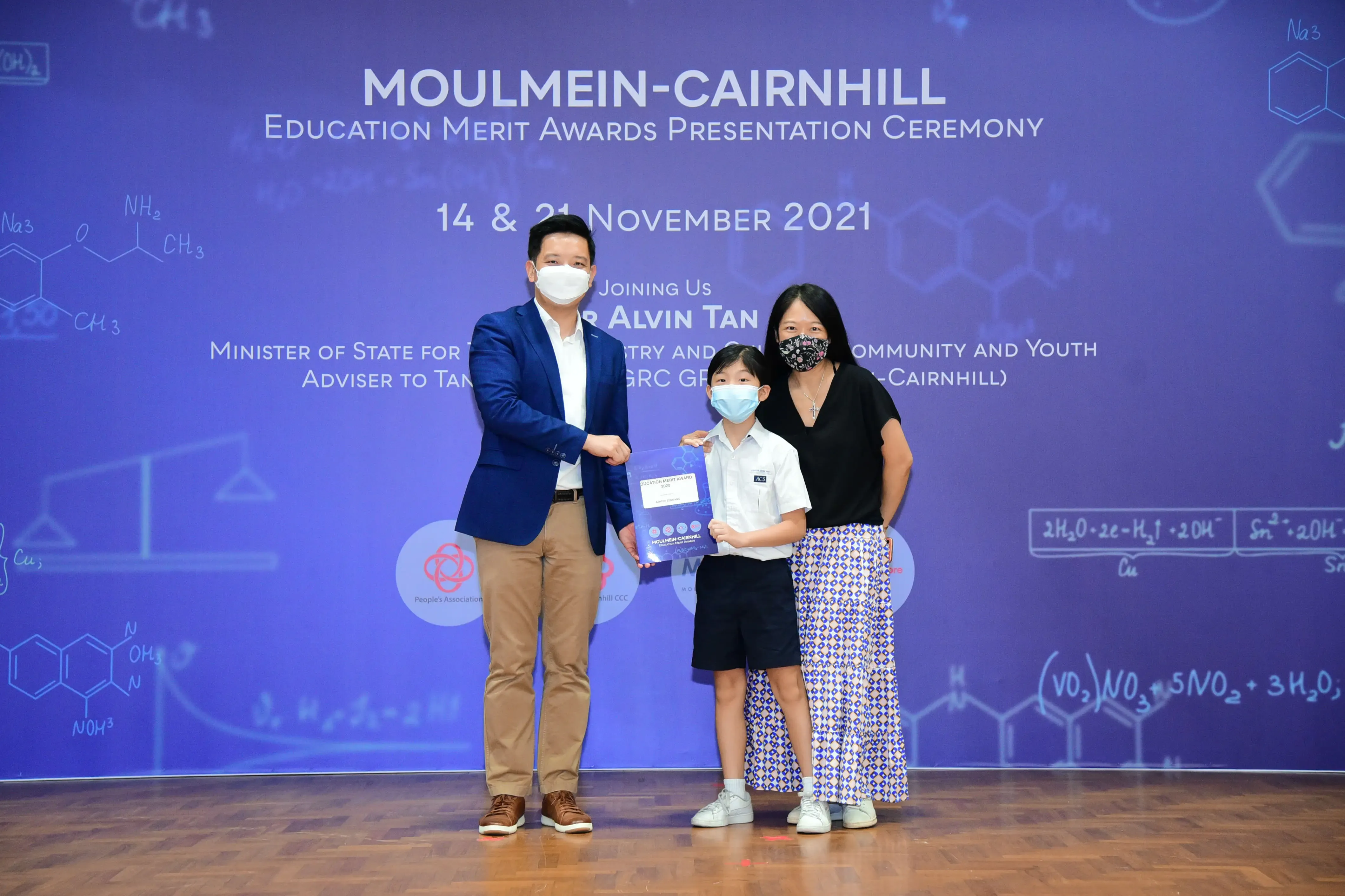Three masked people pose at the Moulmein-Cairnhill Education Merit Awards Presentation Ceremony, November 2021.