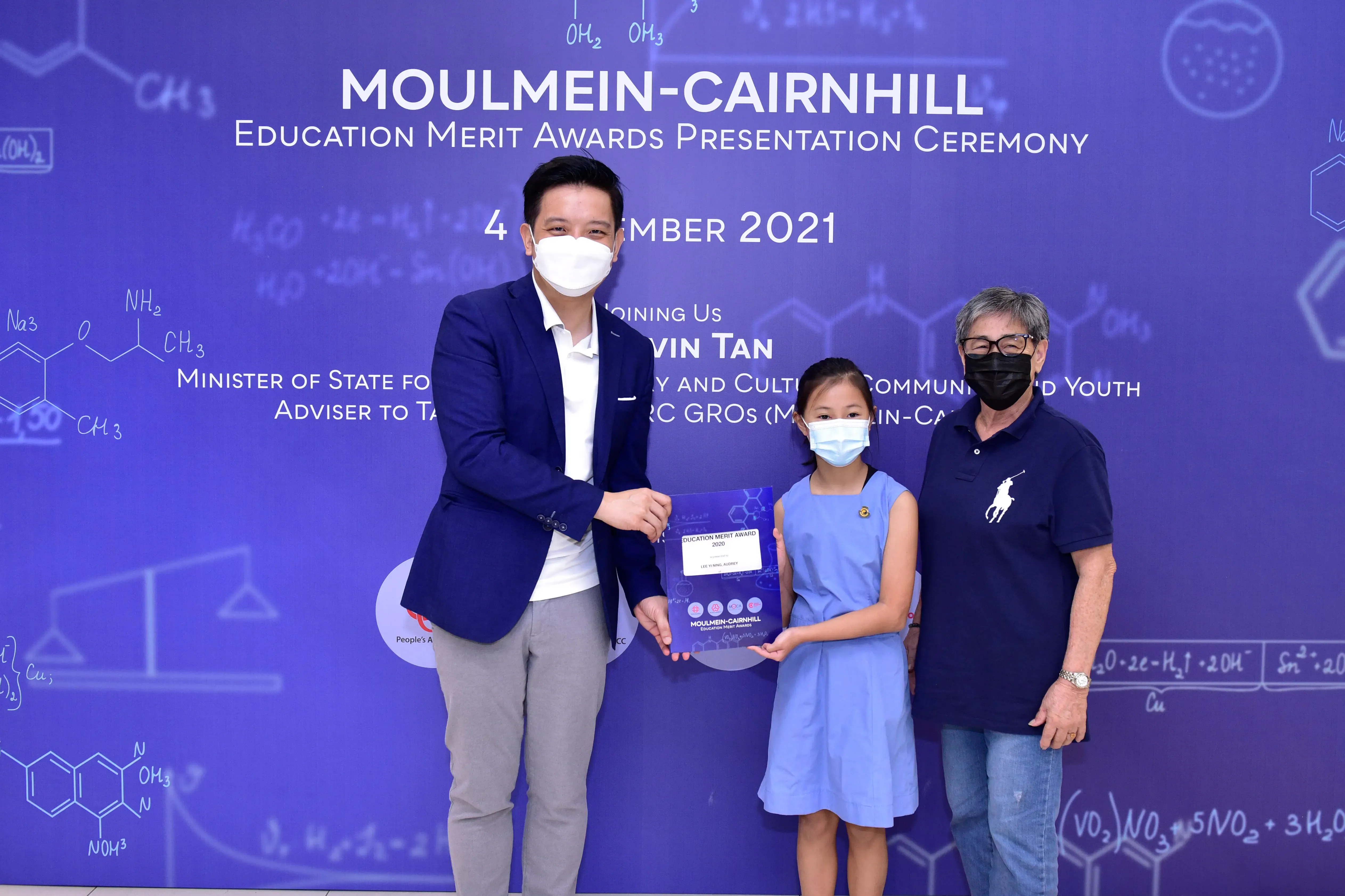 Three masked people pose at the Moulmein-Cairnhill Education Merit Awards Presentation Ceremony 2021.