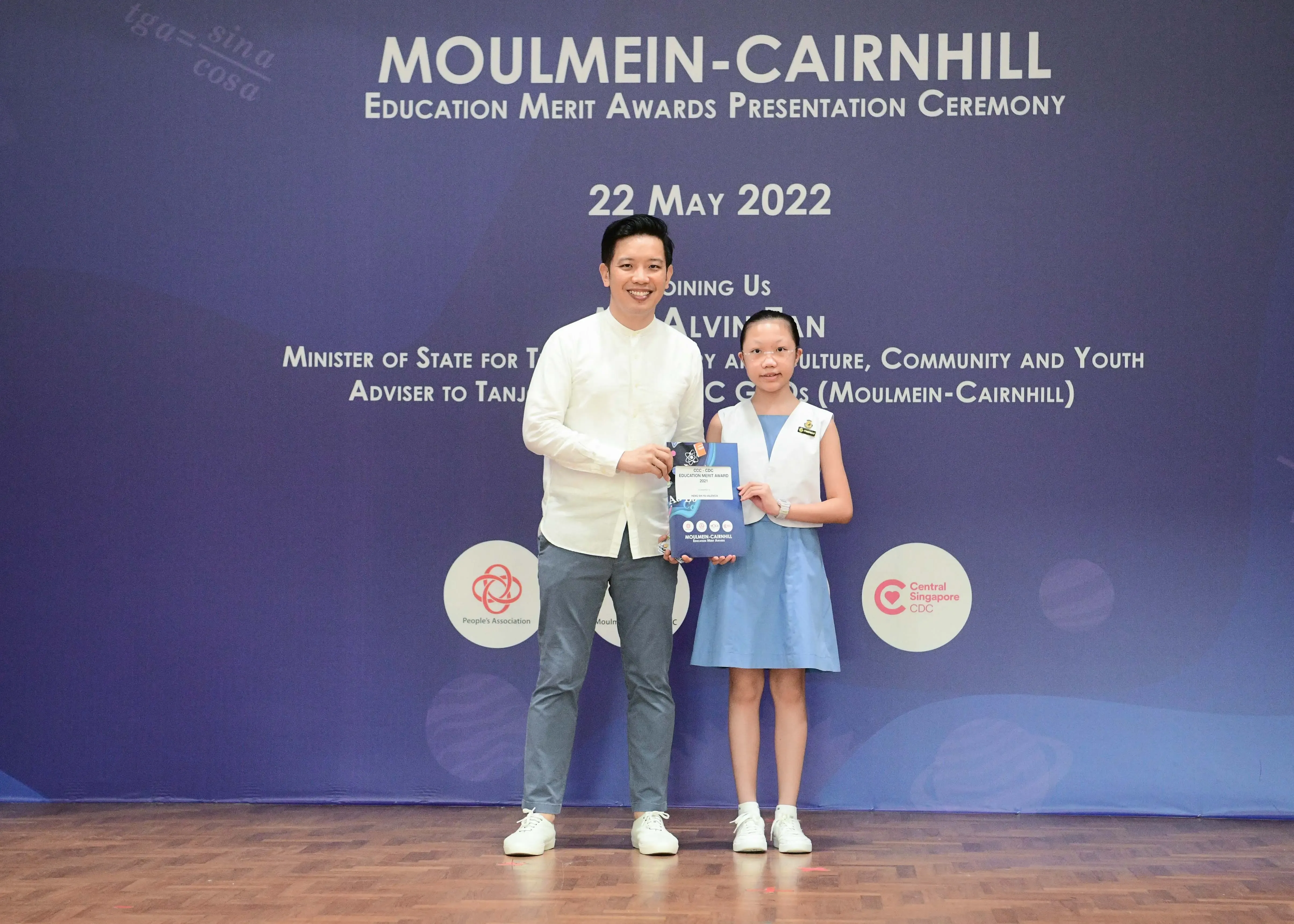 A man and a young girl pose holding an award at the Moulmein-Cairnhill Education Merit Awards Ceremony, 22 May 2022.
