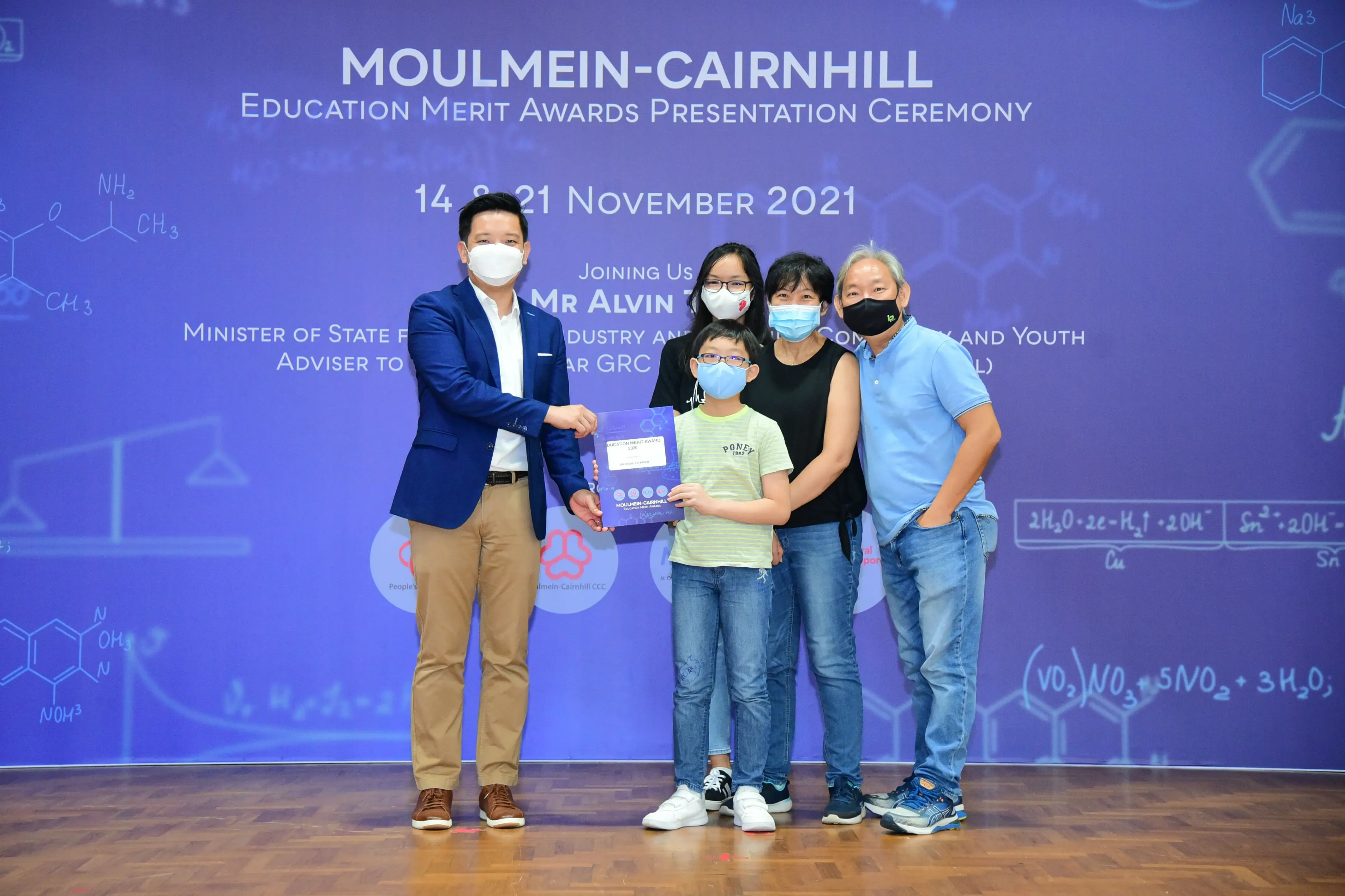 Five masked people pose at the Moulmein-Cairnhill Education Merit Awards Presentation Ceremony, November 2021.