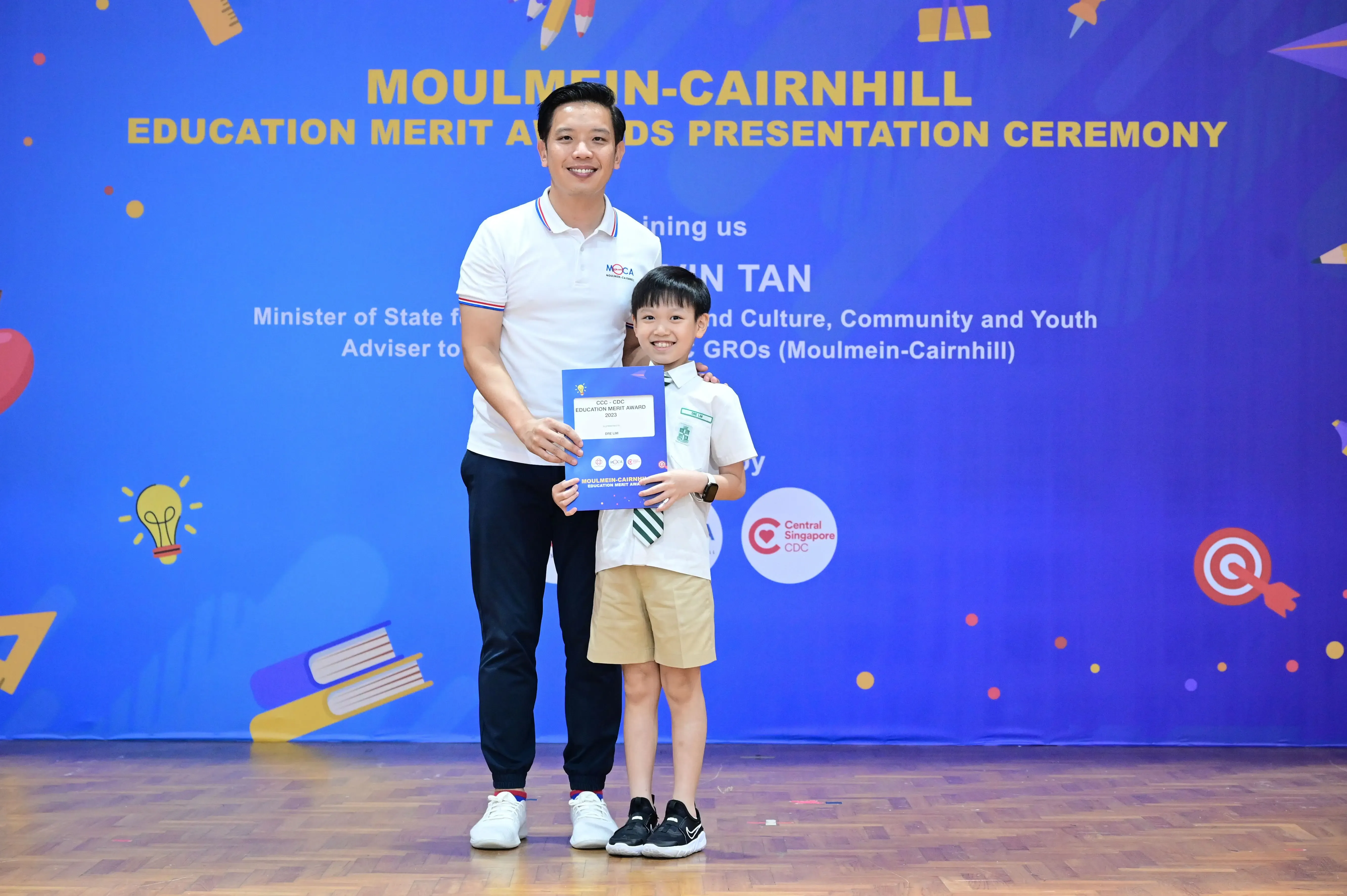 Man and young boy holding a certificate at Moulmein-Cairnhill Education Merit Awards Presentation Ceremony.