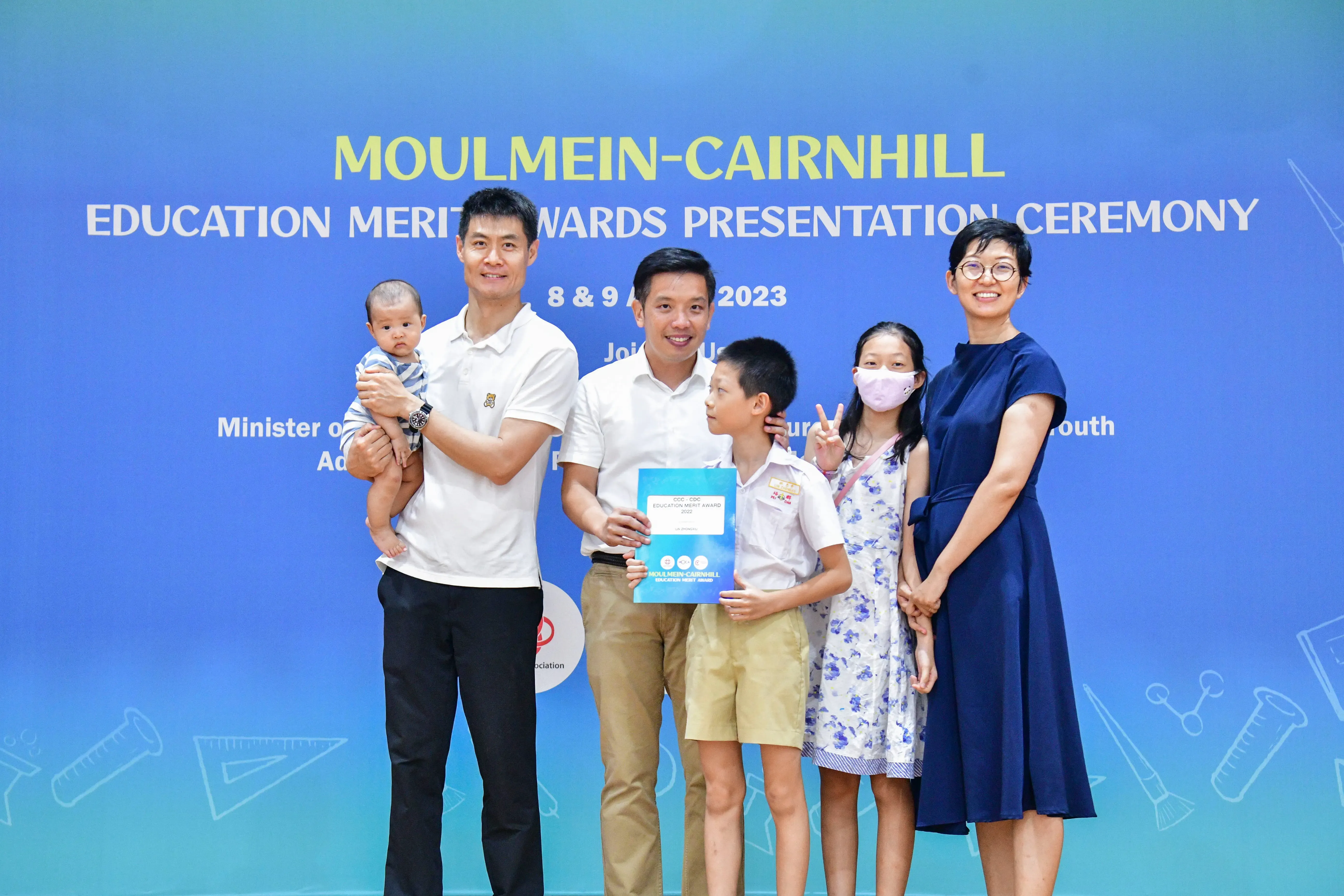 Five people and a baby pose at the Moulmein-Cairnhill Education Merit Awards Presentation Ceremony 2023.