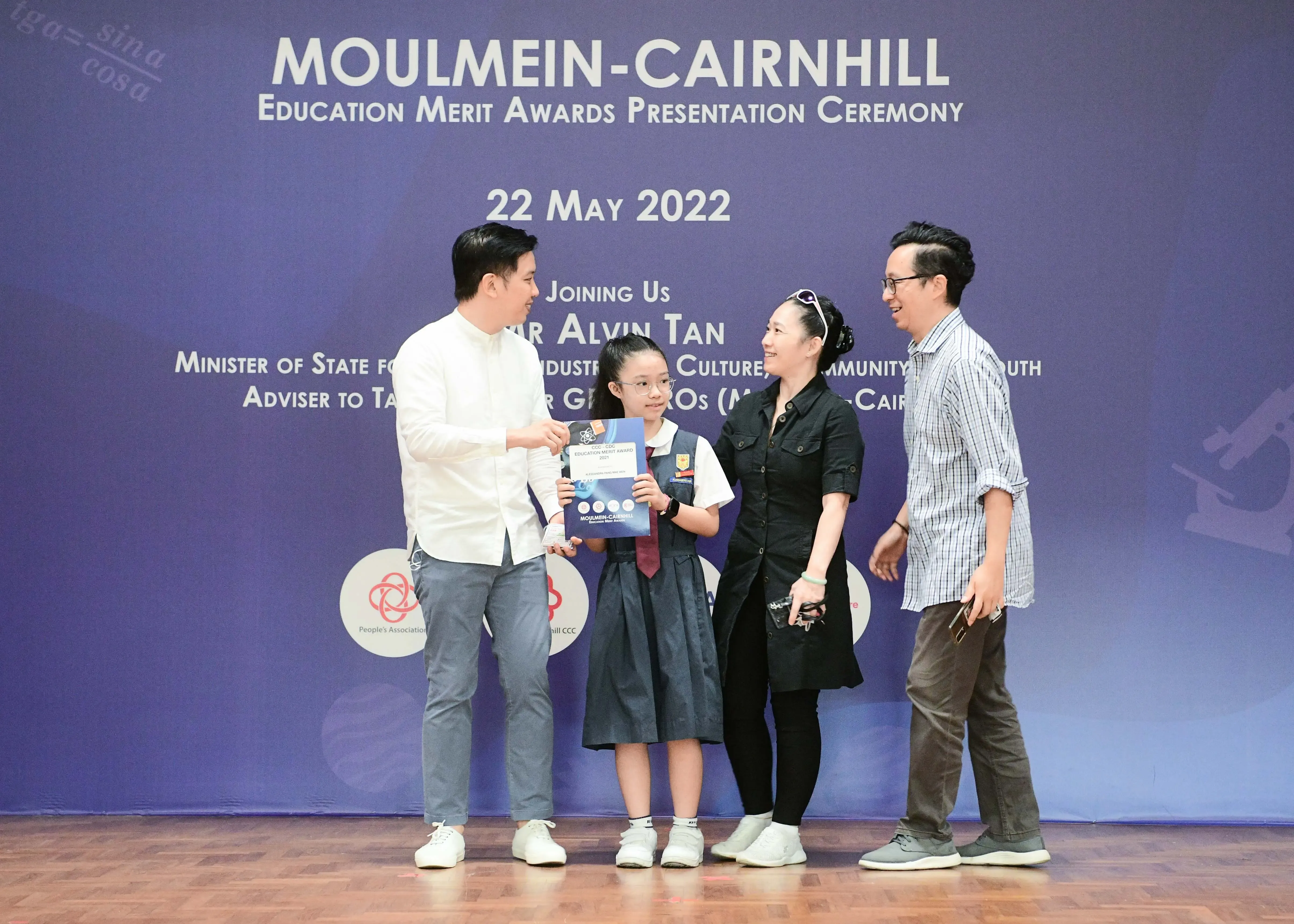 A young student in school uniform holds a certificate at the Moulmein-Cairnhill Education Merit Awards ceremony on 22 May 2022.