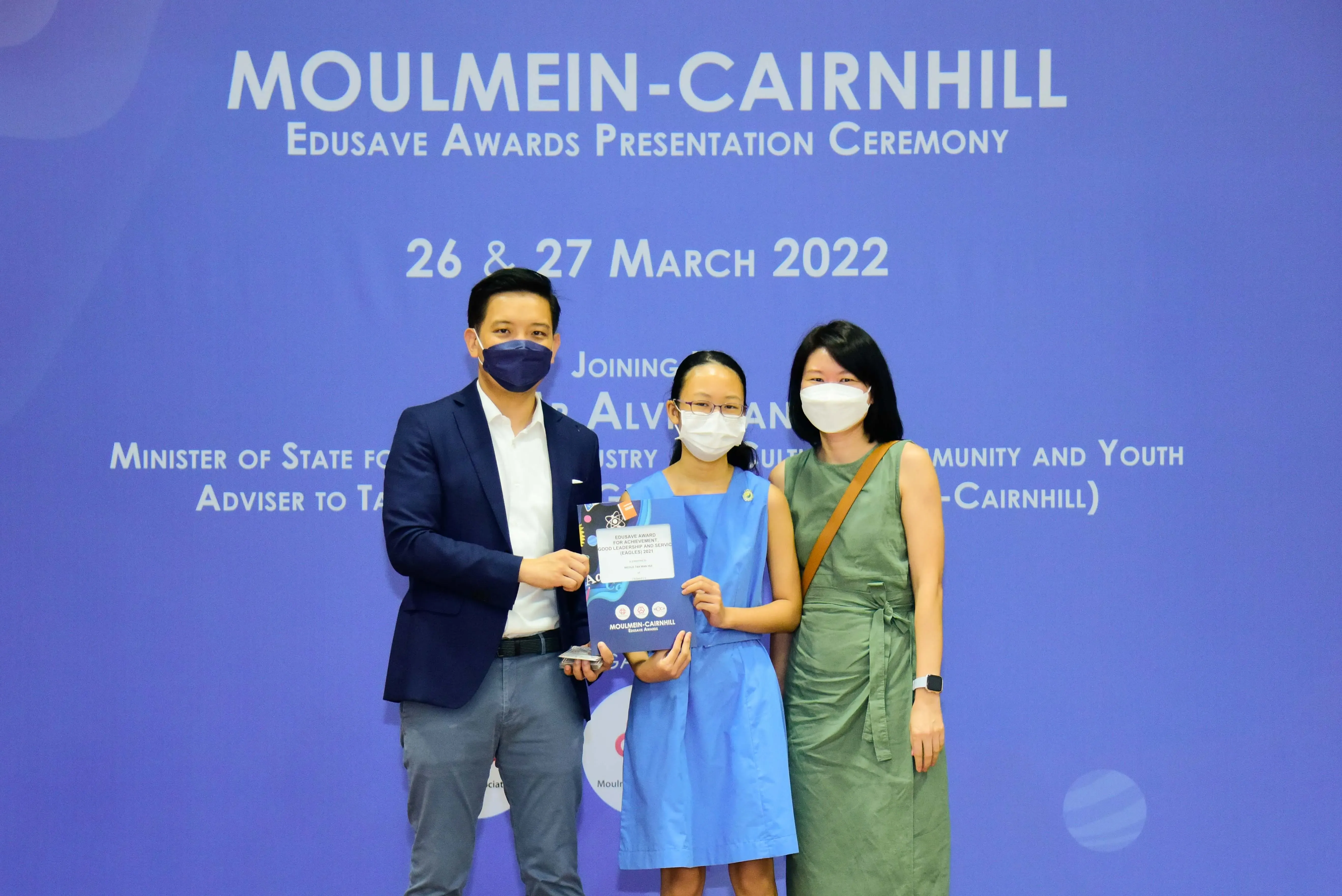 Three masked people pose at the Moulmein-Cairnhill Edusave Awards Presentation Ceremony on 26-27 March 2022.