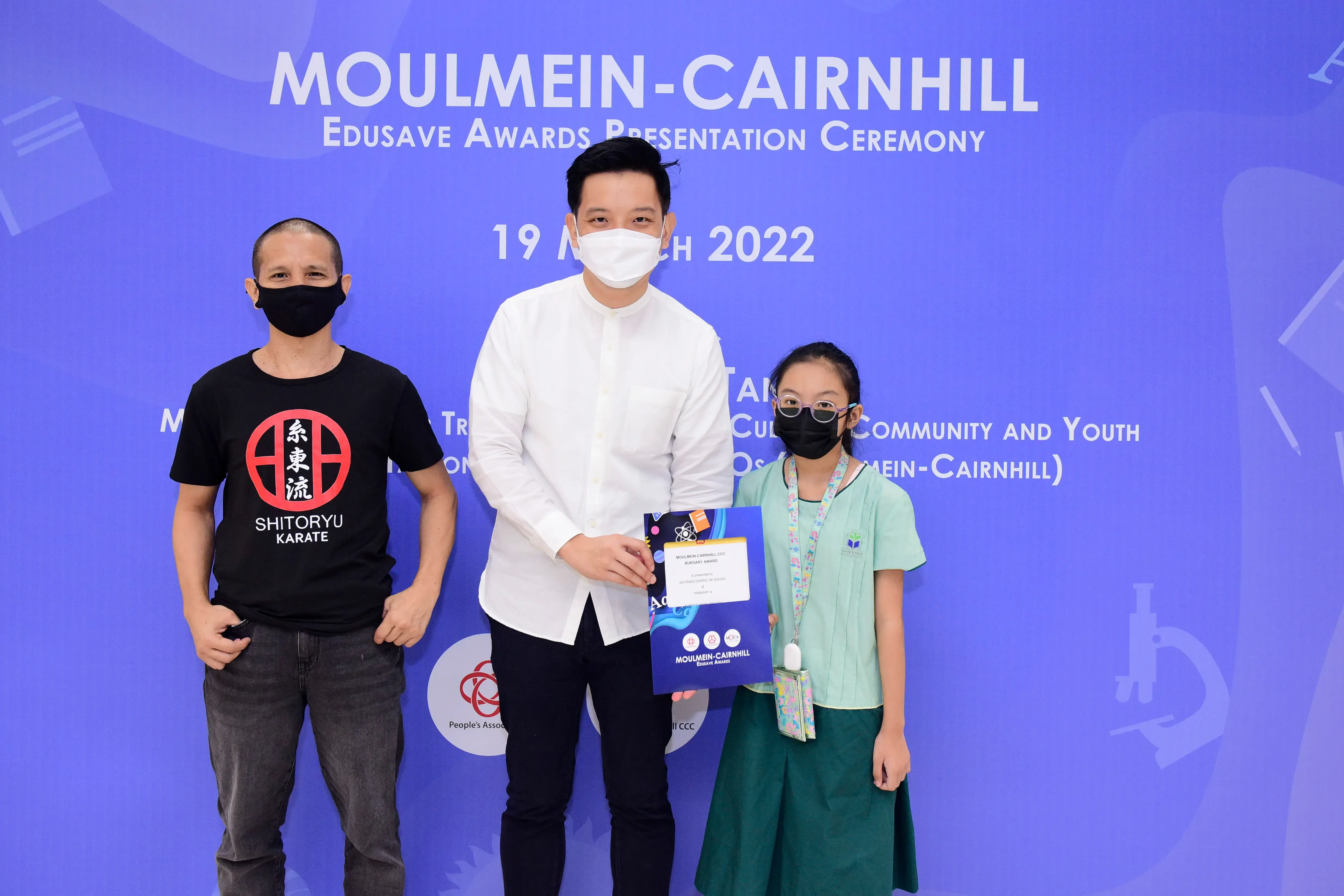 Three masked people pose at the Moulmein-Cairnhill Edusave Awards Presentation Ceremony on 19 March 2022.