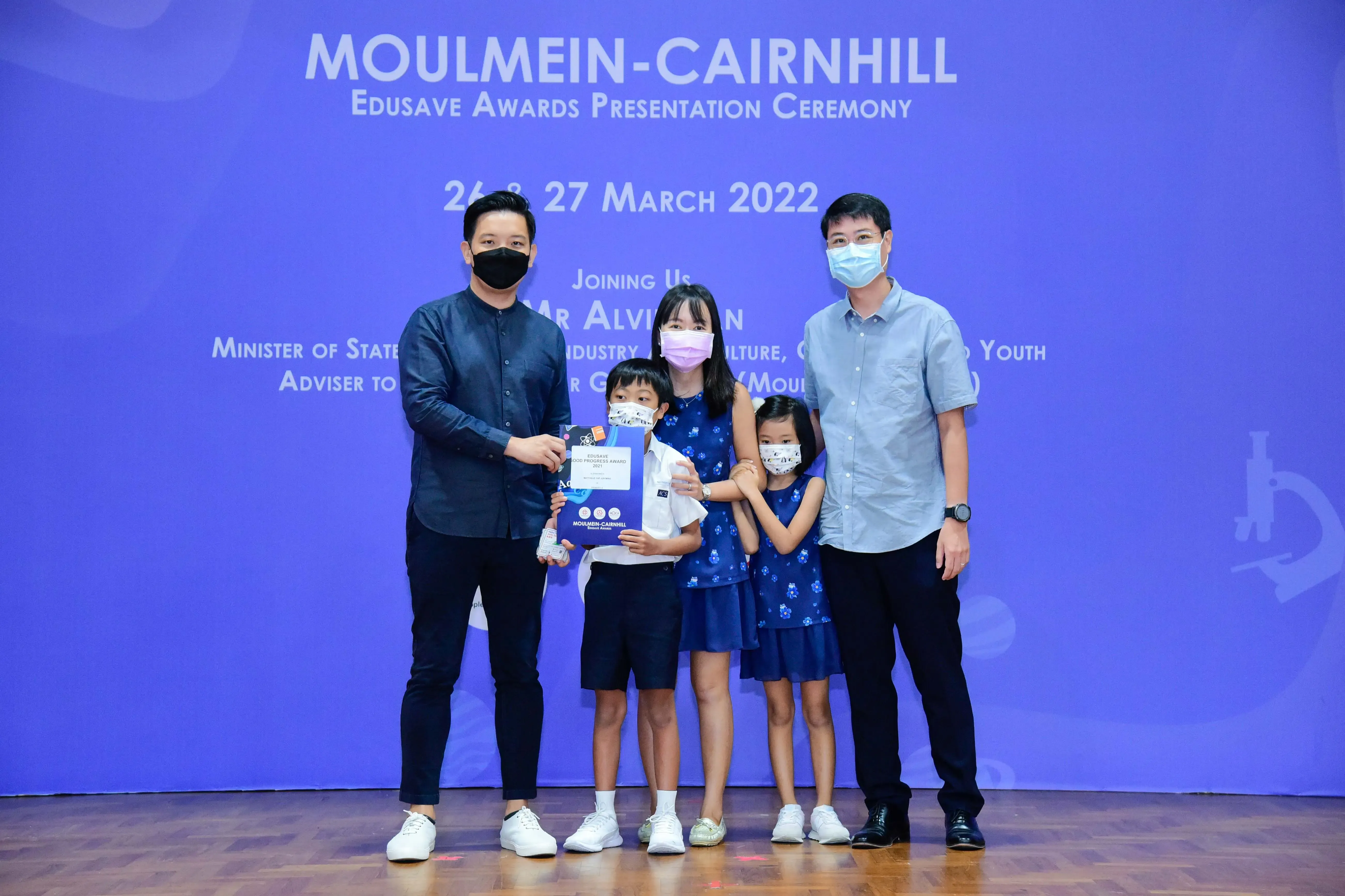 Five masked people pose at the Moulmein-Cairnhill Edusave Awards Presentation Ceremony on 26-27 March 2022.