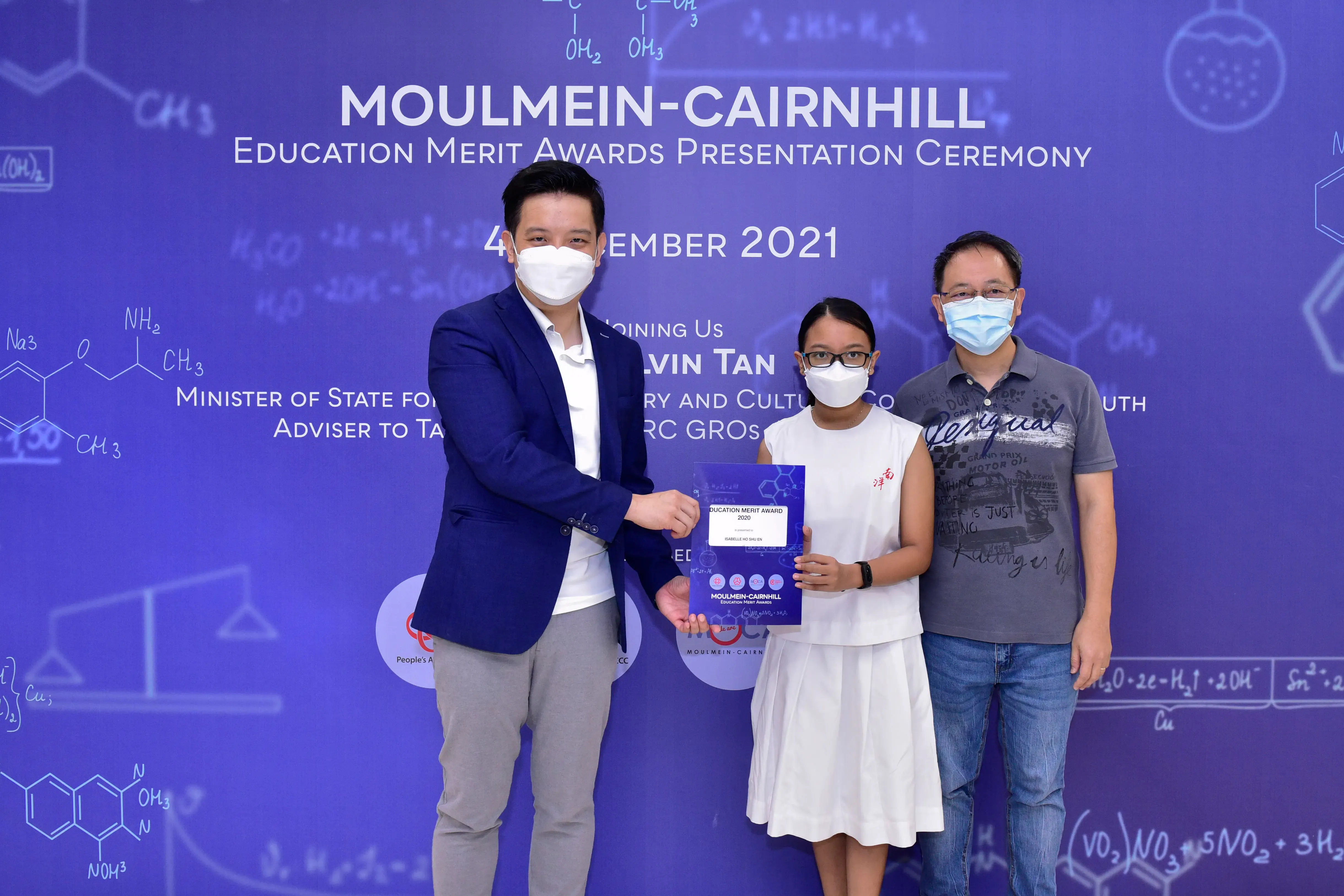 Three masked people pose at the Moulmein-Cairnhill Education Merit Awards Presentation Ceremony 2021.