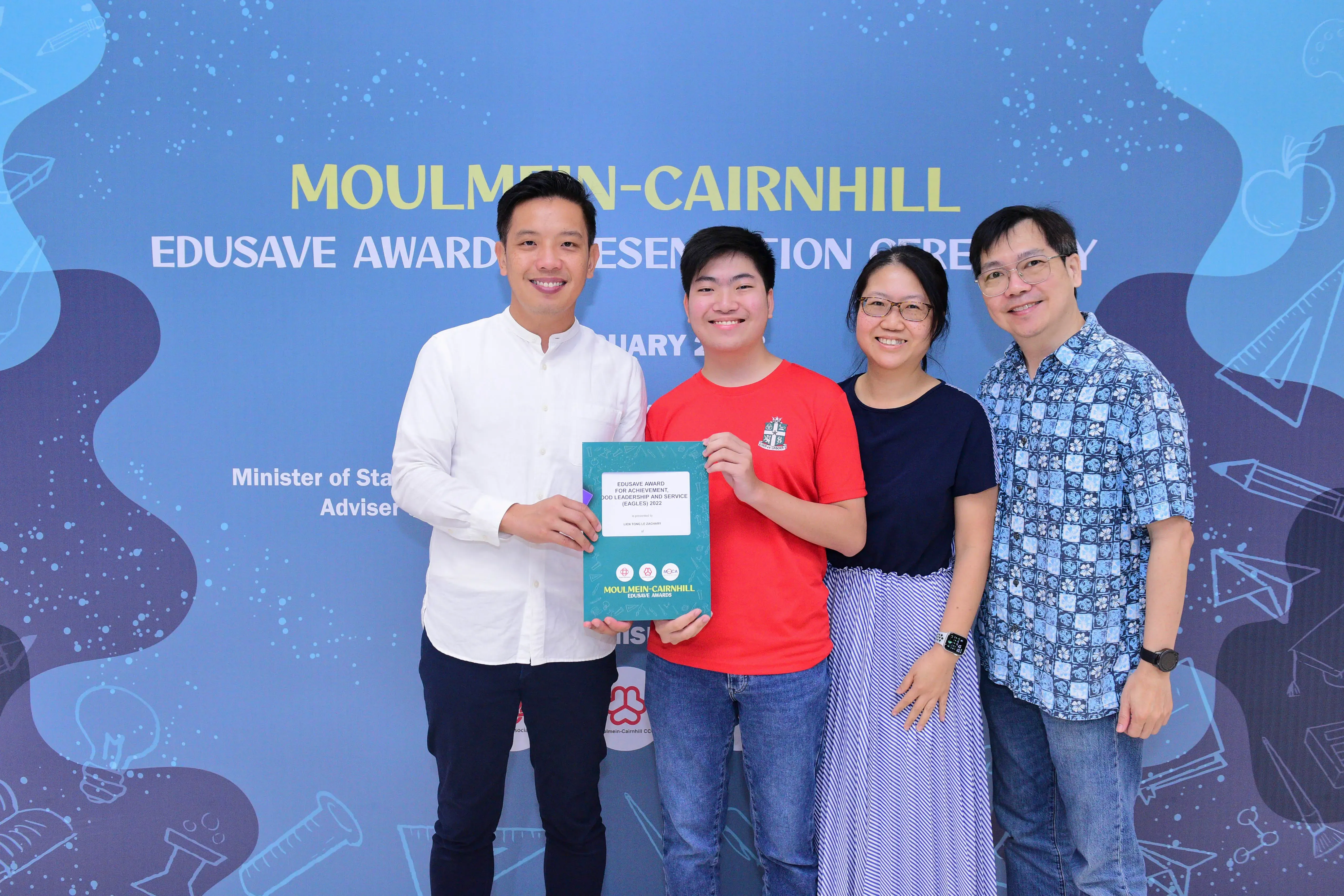 Four people smile holding an Edusave award at the Moulmein-Cairnhill Edusave Awards Presentation Ceremony.