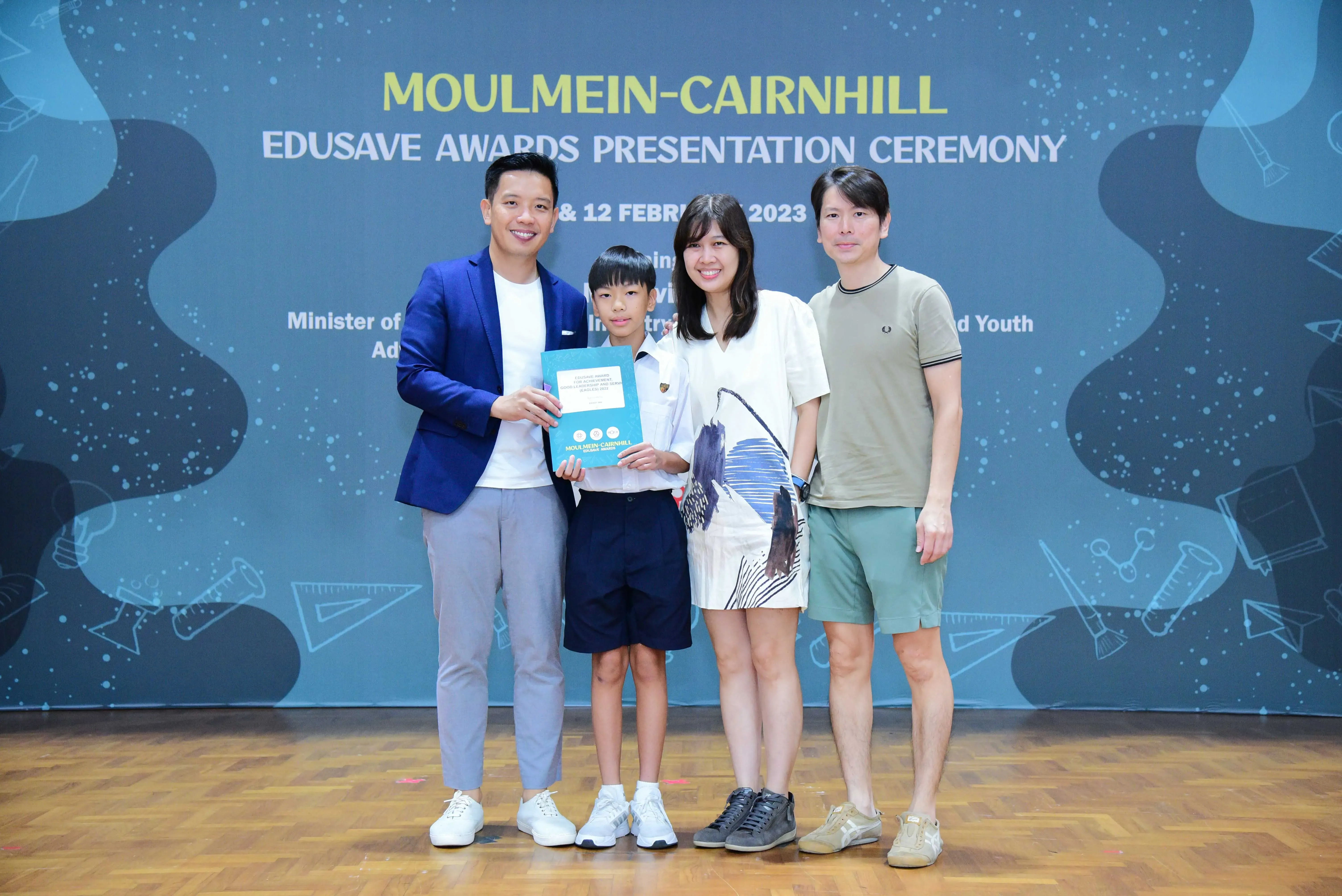 Four people pose together at the Moulmein-Cairnhill Edusave Awards Presentation Ceremony 2023, holding a certificate.