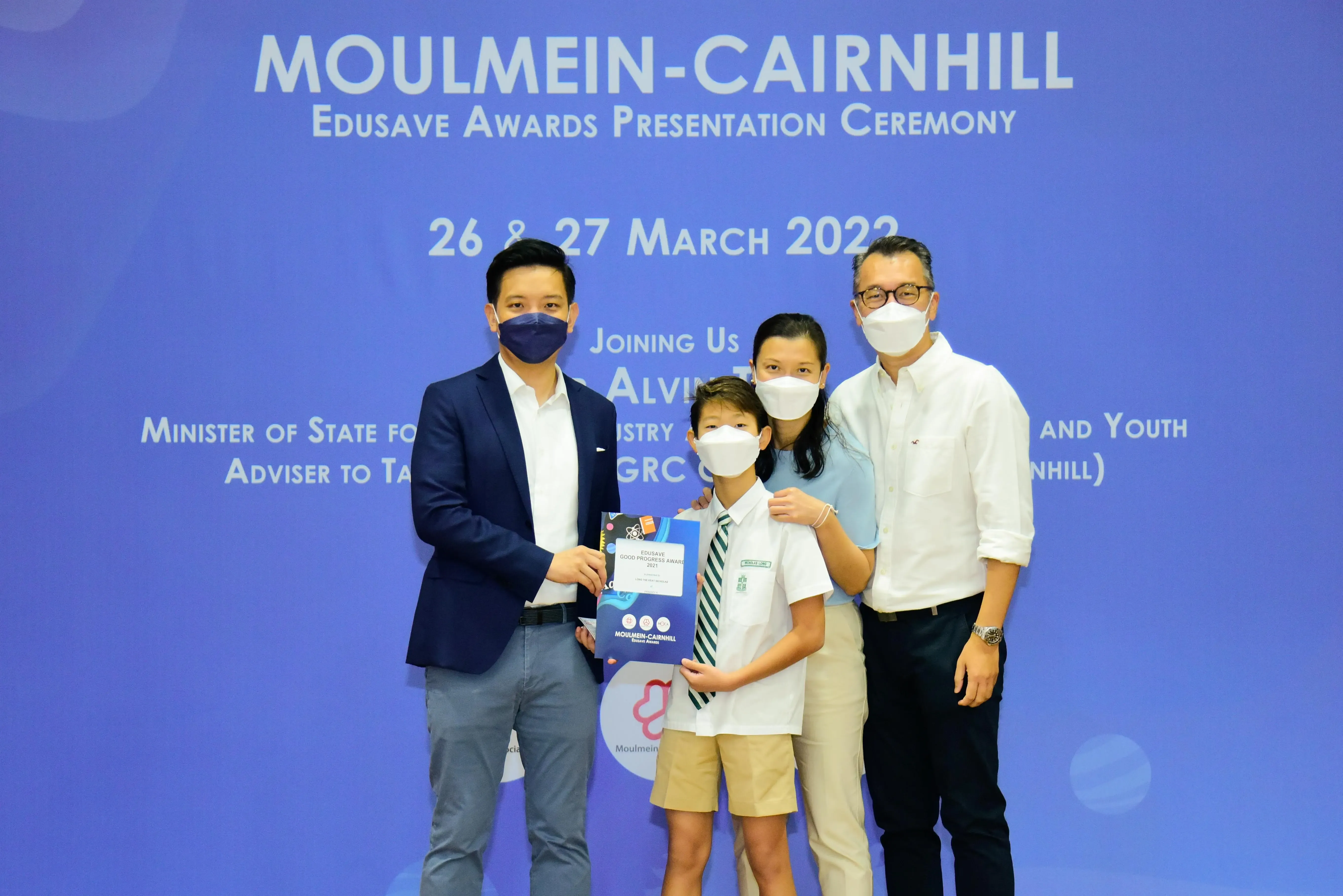 Four masked people pose at the Moulmein-Cairnhill Edusave Awards Presentation Ceremony on 26-27 March 2022.