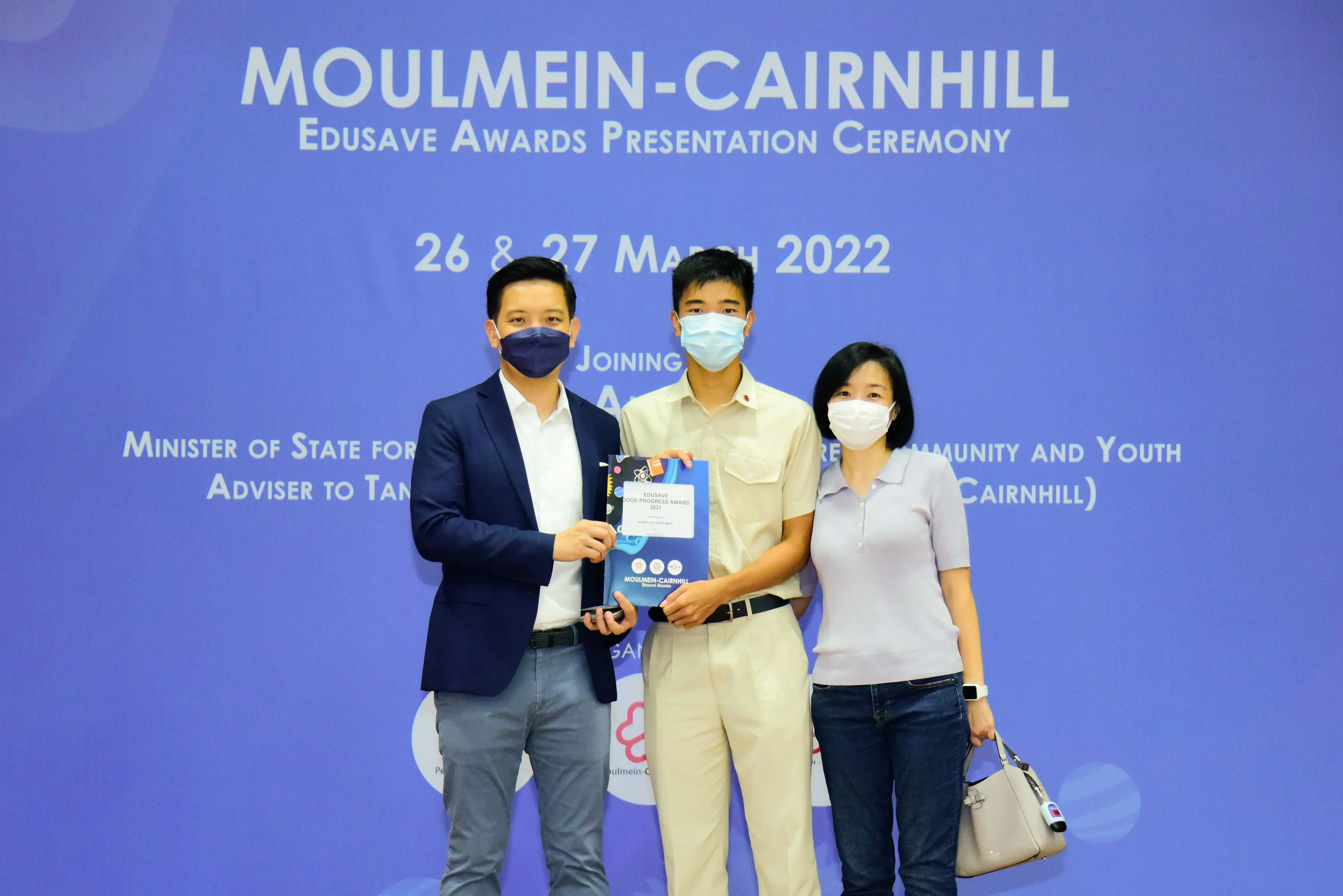Three masked people pose at the Moulmein-Cairnhill Edusave Awards Presentation Ceremony on 26-27 March 2022.