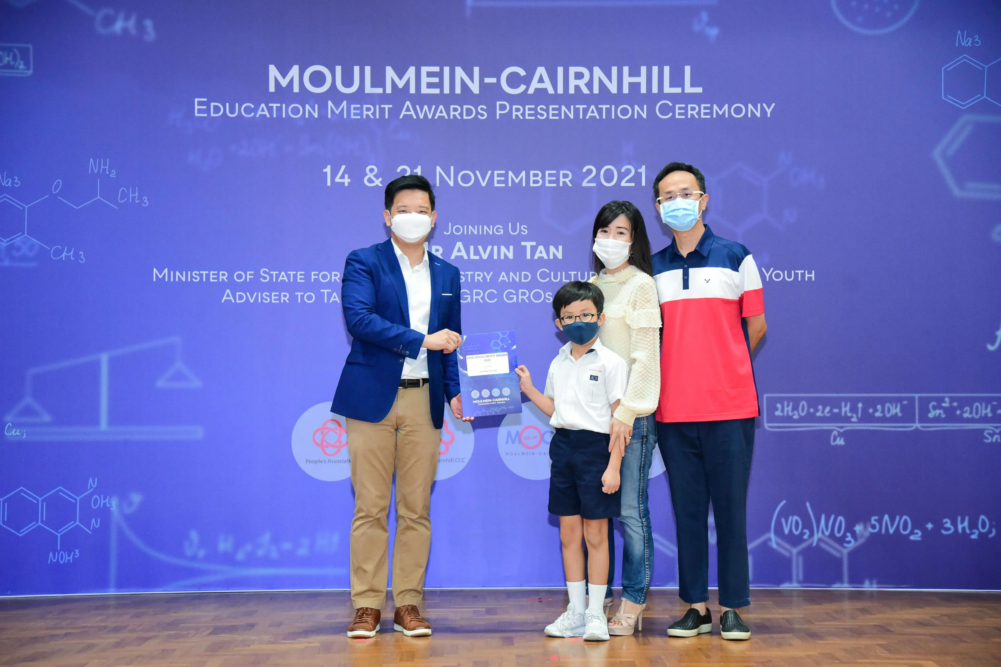 Four masked people pose at the Moulmein-Cairnhill Education Merit Awards Presentation Ceremony, November 2021.