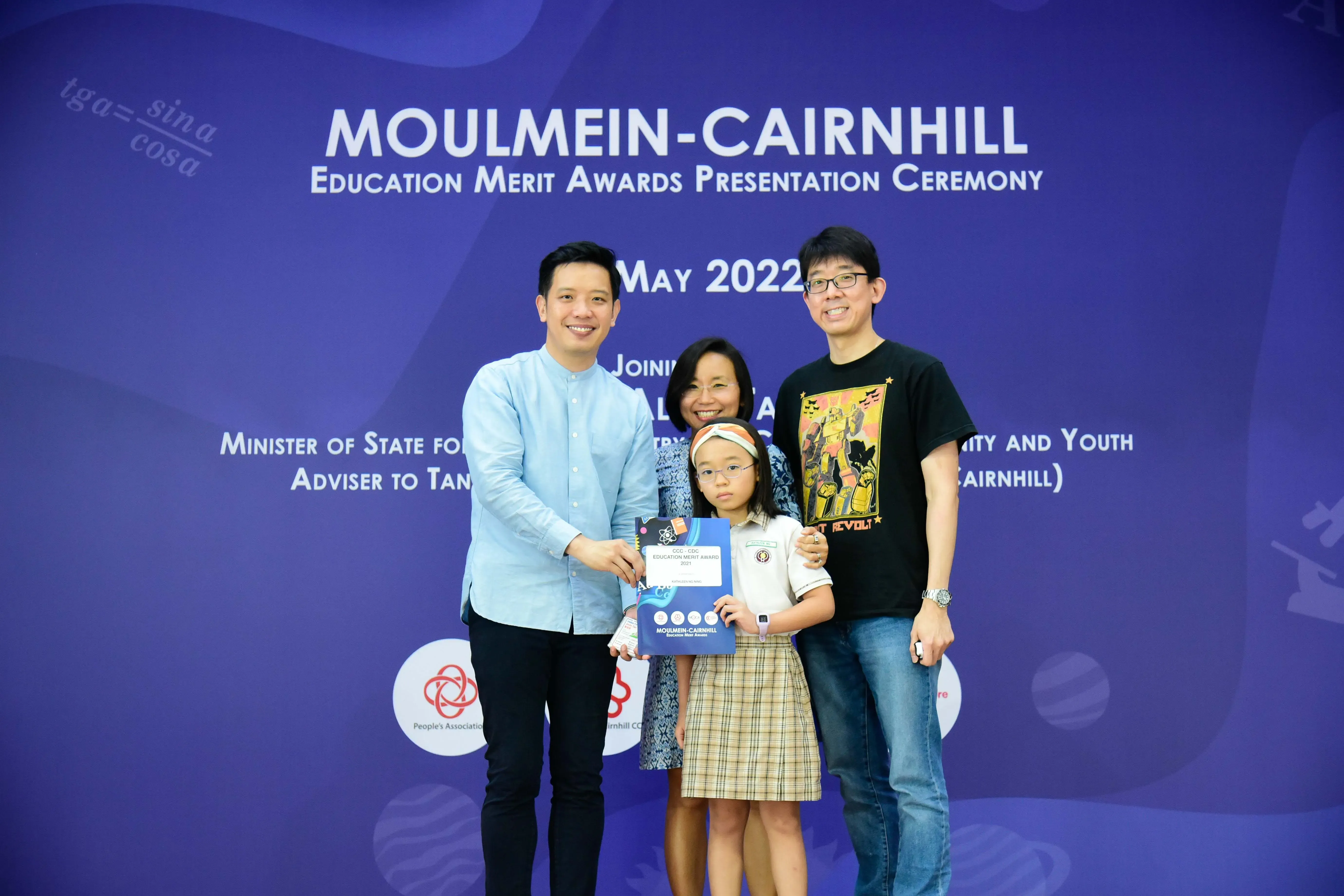 Three adults and a young girl holding an award certificate pose at the Moulmein-Cairnhill Education Merit Awards May 2022.
