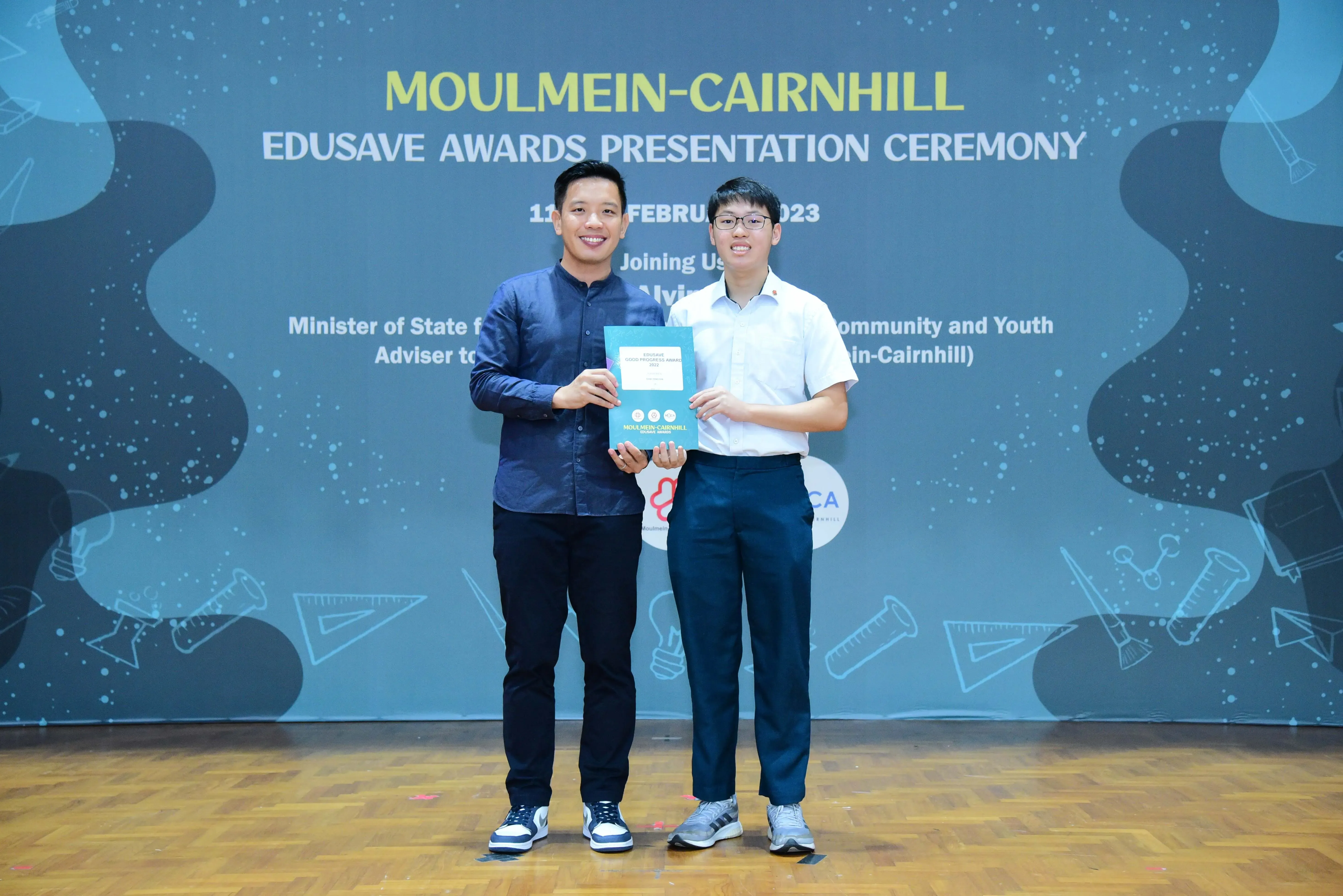 Two men pose holding a certificate at the Moulmein-Cairnhill Edusave Awards Presentation Ceremony 2023.