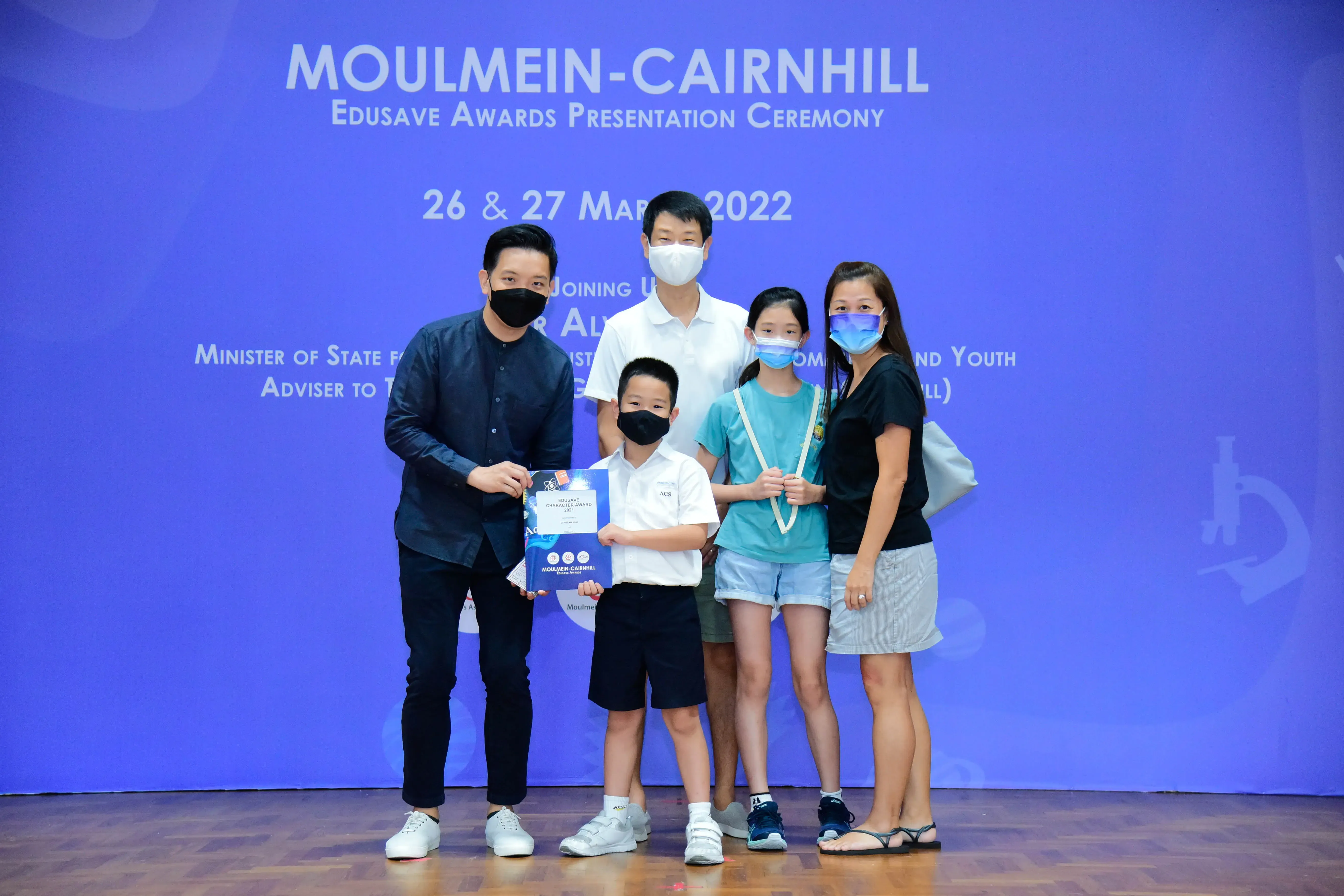 Five masked people pose at the Moulmein-Cairnhill Edusave Awards Presentation Ceremony on 26 & 27 March 2022.