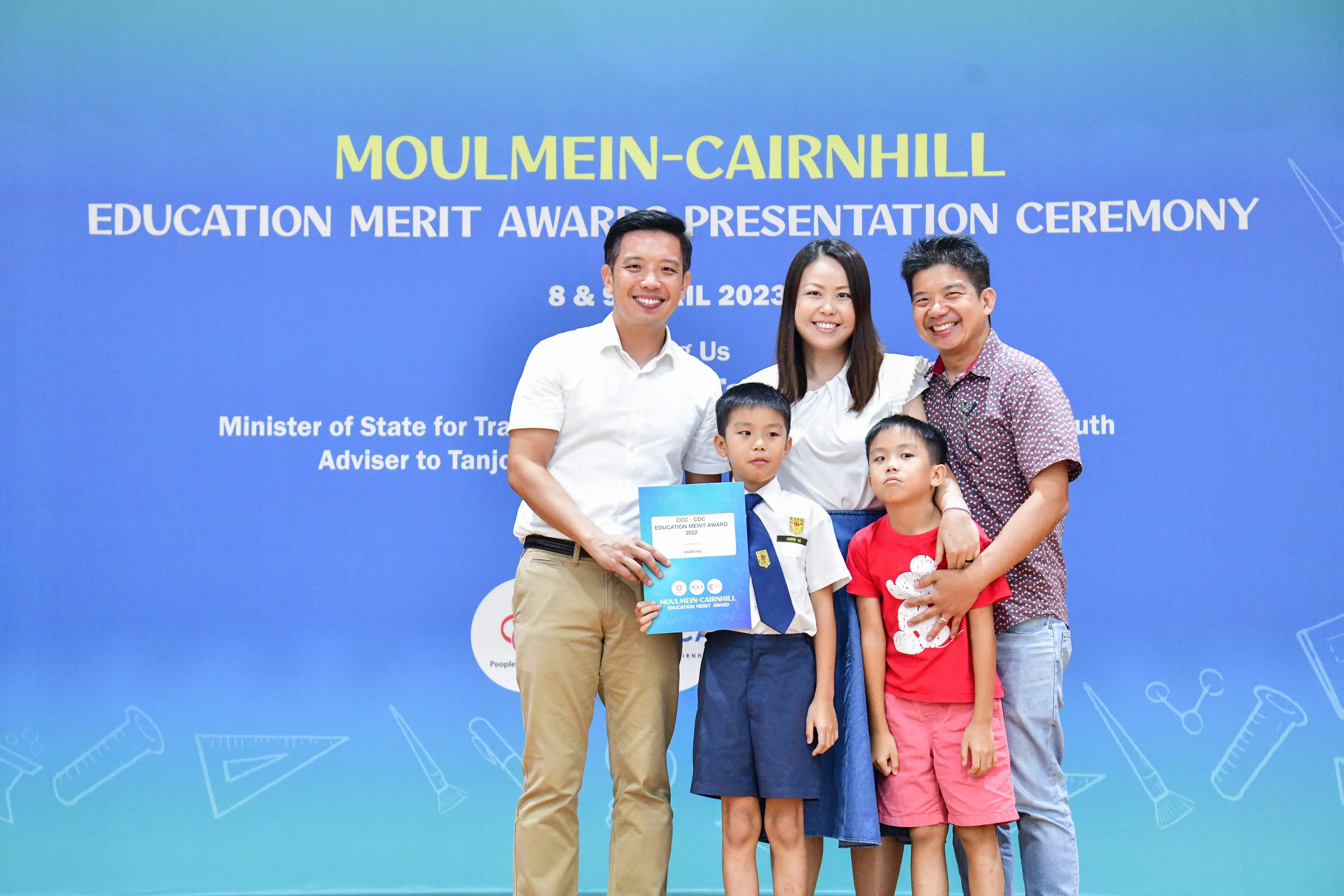 Three adults and two children pose smiling at the Moulmein-Cairnhill Education Merit Awards Presentation Ceremony 2023.