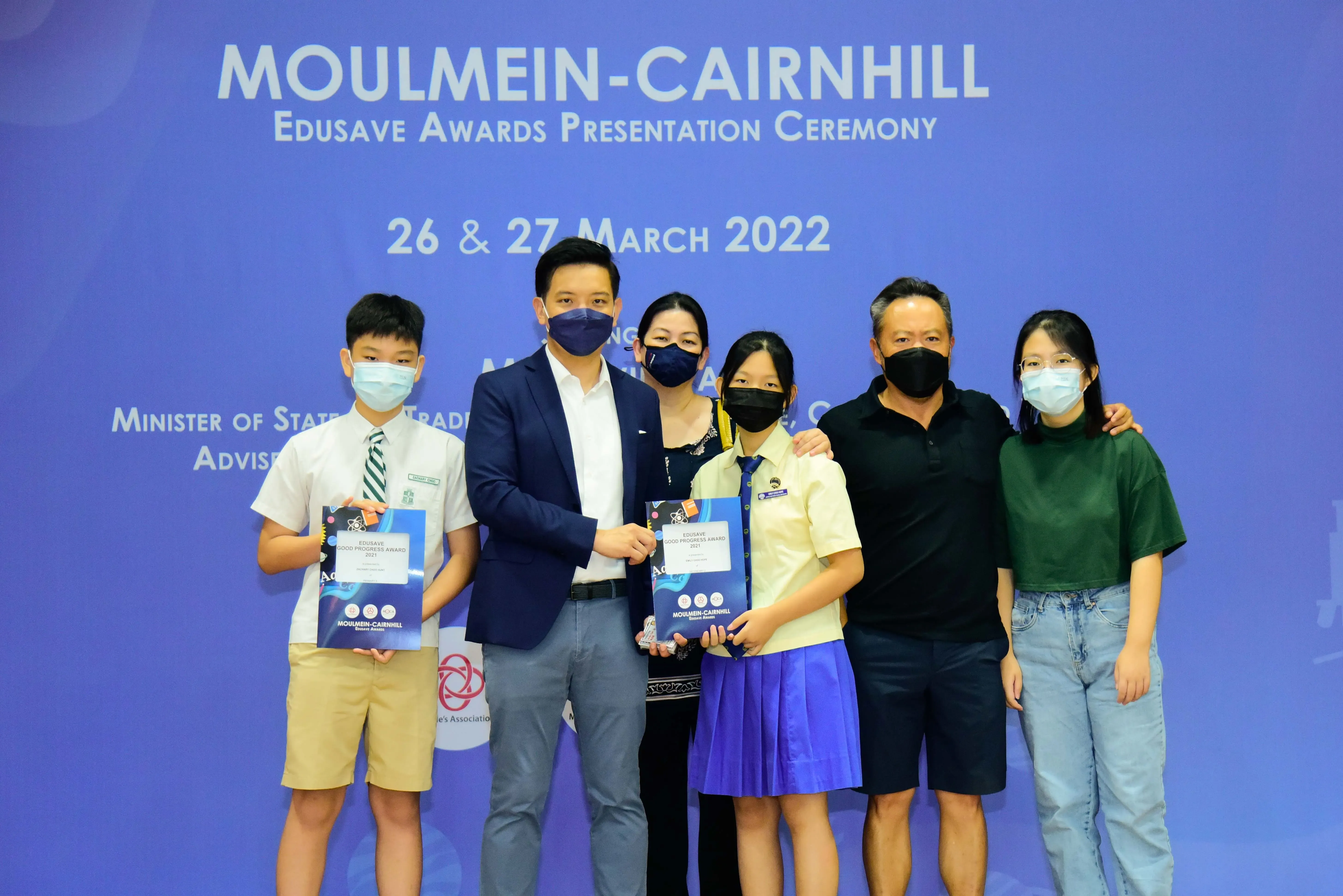 Six masked people pose at the Moulmein-Cairnhill Edusave Awards Presentation Ceremony on 26-27 March 2022.