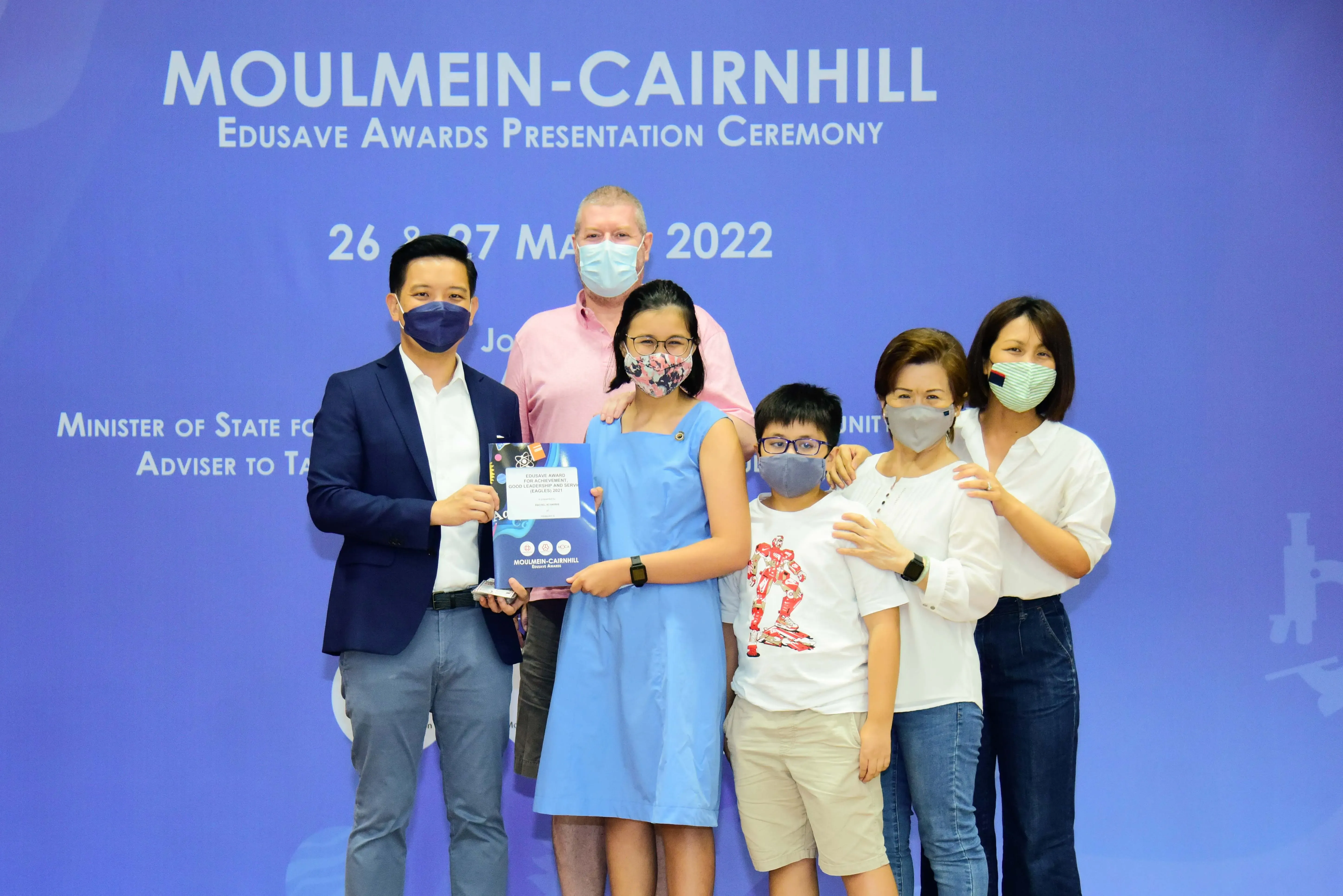 Six masked people pose at the Moulmein-Cairnhill Edusave Awards Presentation Ceremony on 26-27 March 2022.