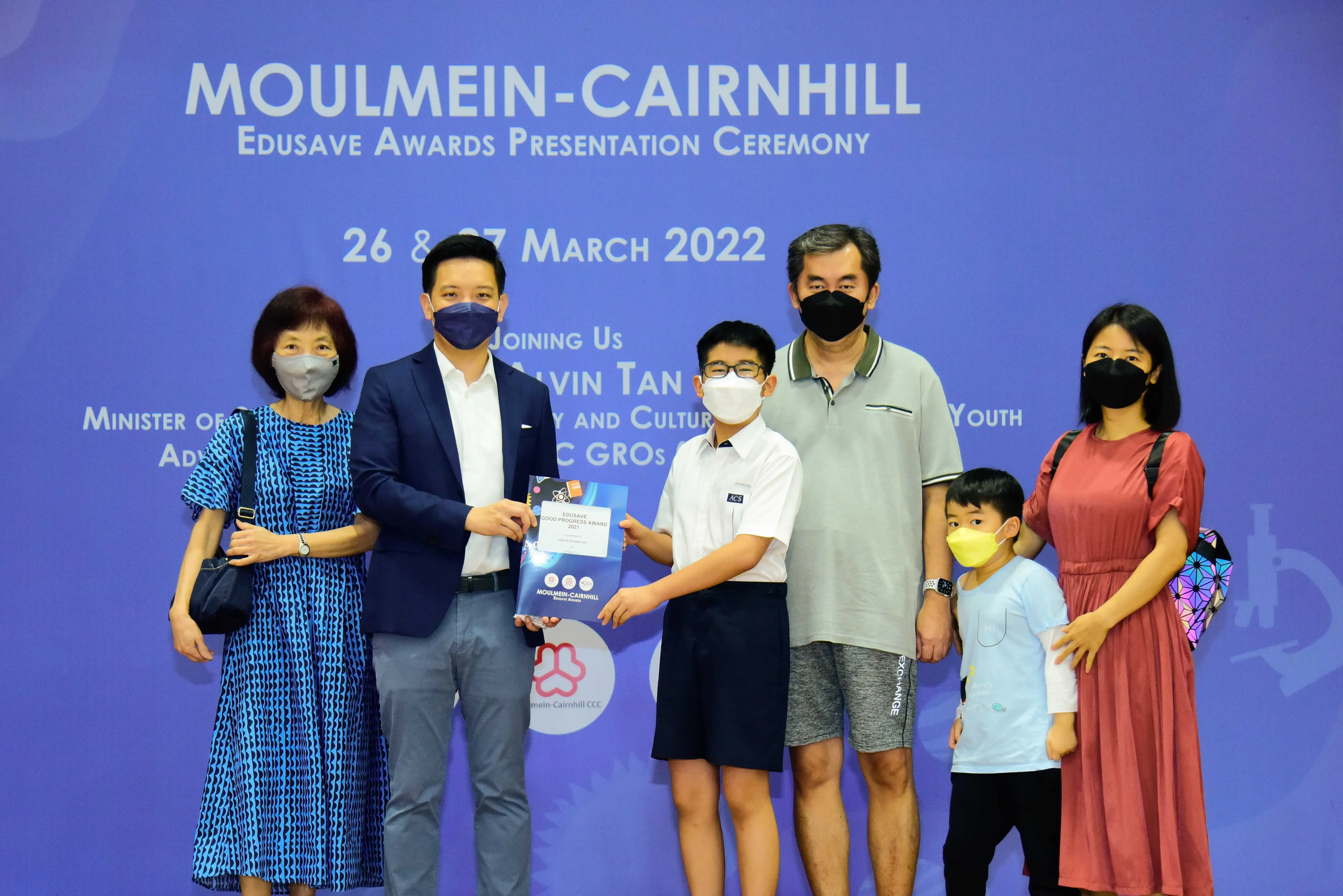 Six masked people pose at the Moulmein-Cairnhill Edusave Awards Presentation Ceremony on 26-27 March 2022.