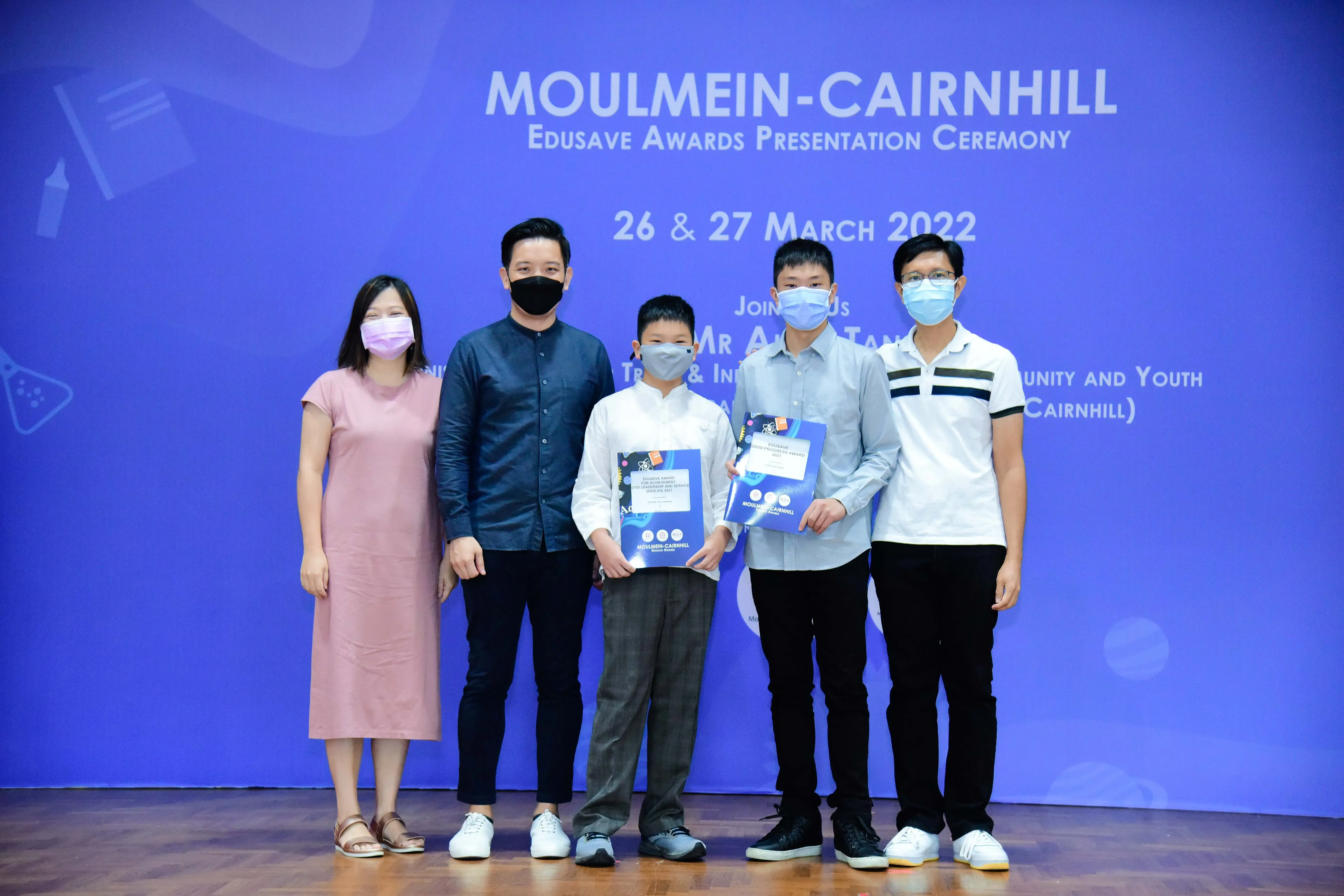Five masked people pose at the Moulmein-Cairnhill Edusave Awards Presentation Ceremony on 26-27 March 2022.