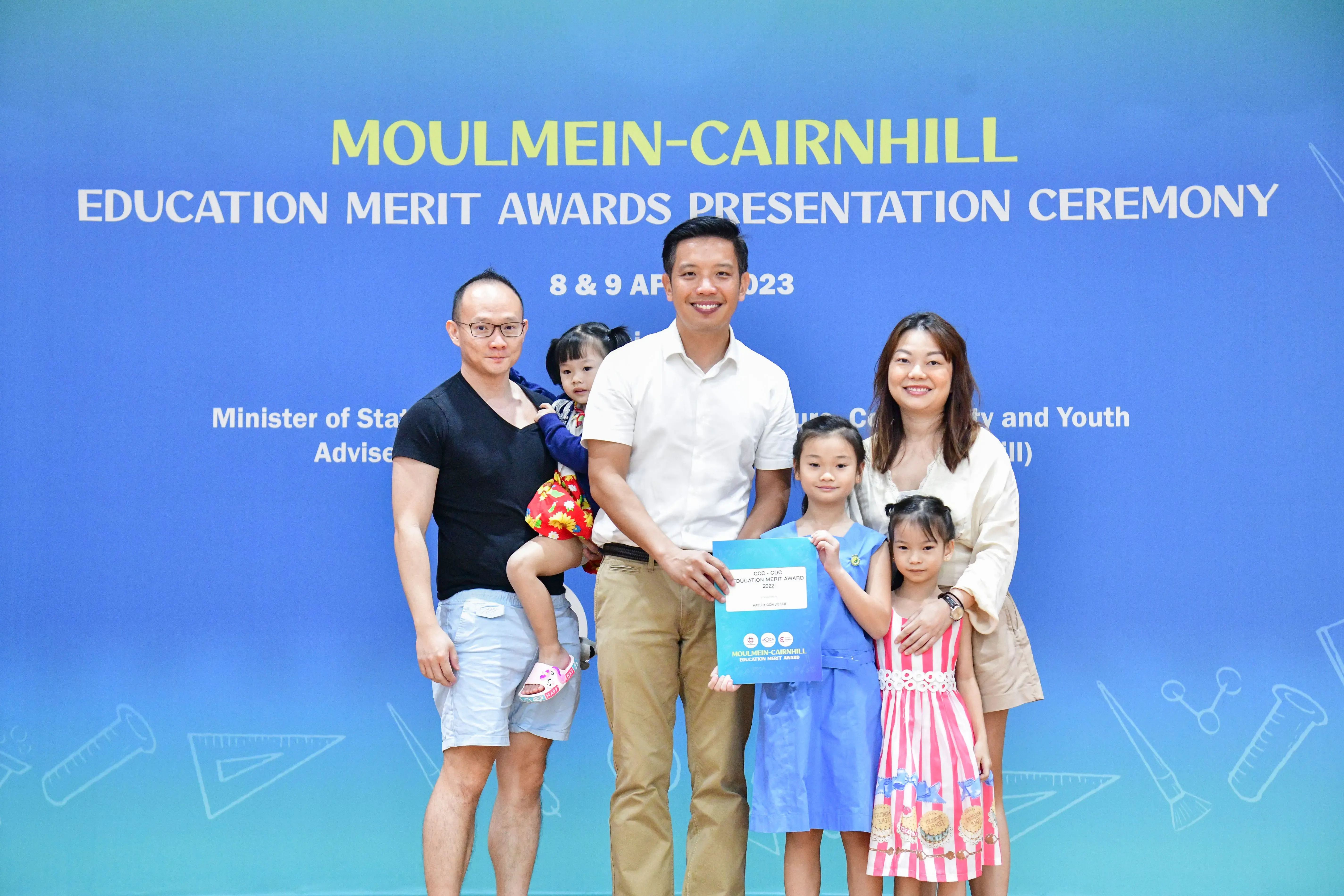 Five people including two young girls pose at the Moulmein-Cairnhill Education Merit Awards Ceremony, April 2023.