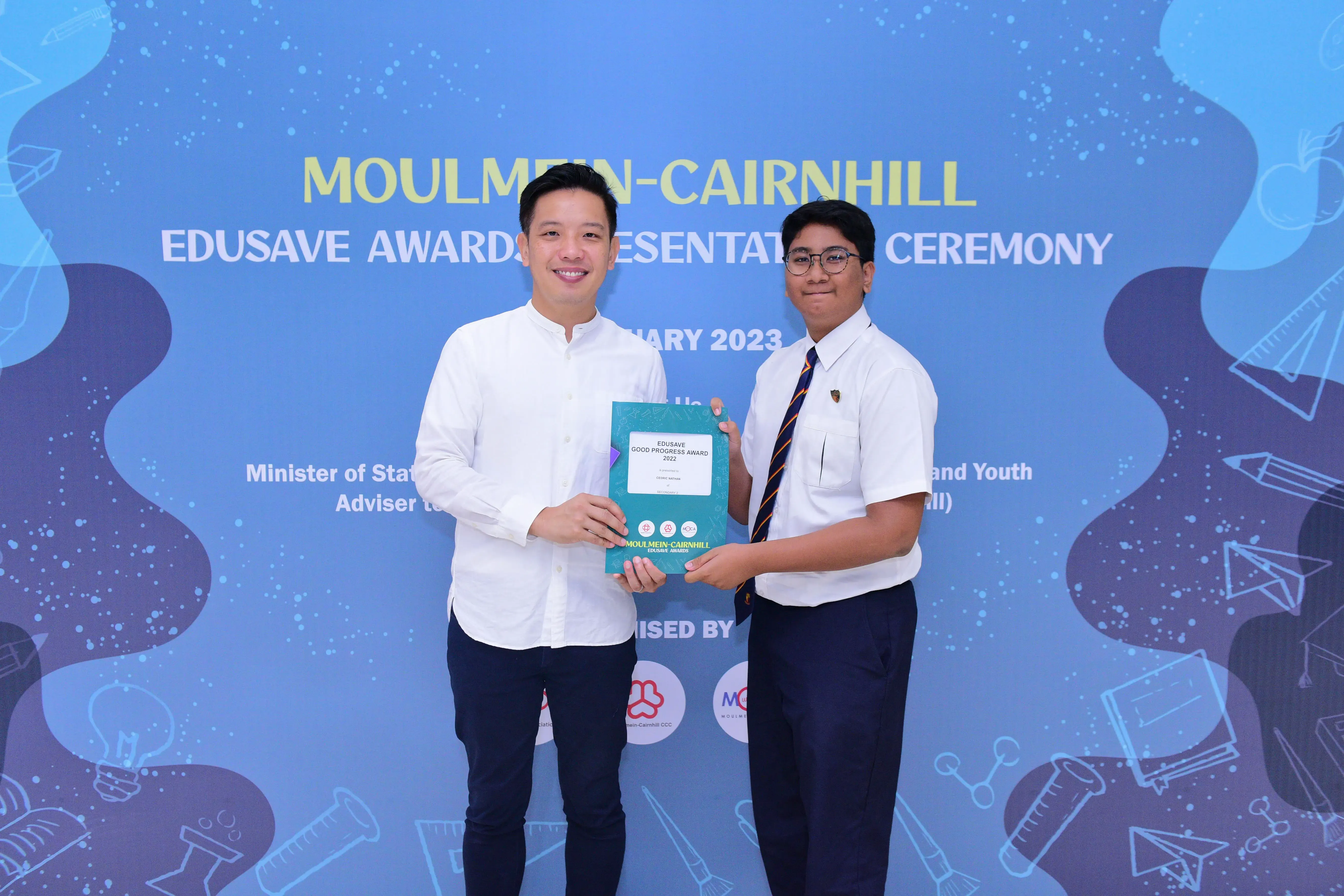Two people hold an Edusave award certificate at the Moulmein-Cairnhill Edusave Awards Presentation Ceremony 2023.