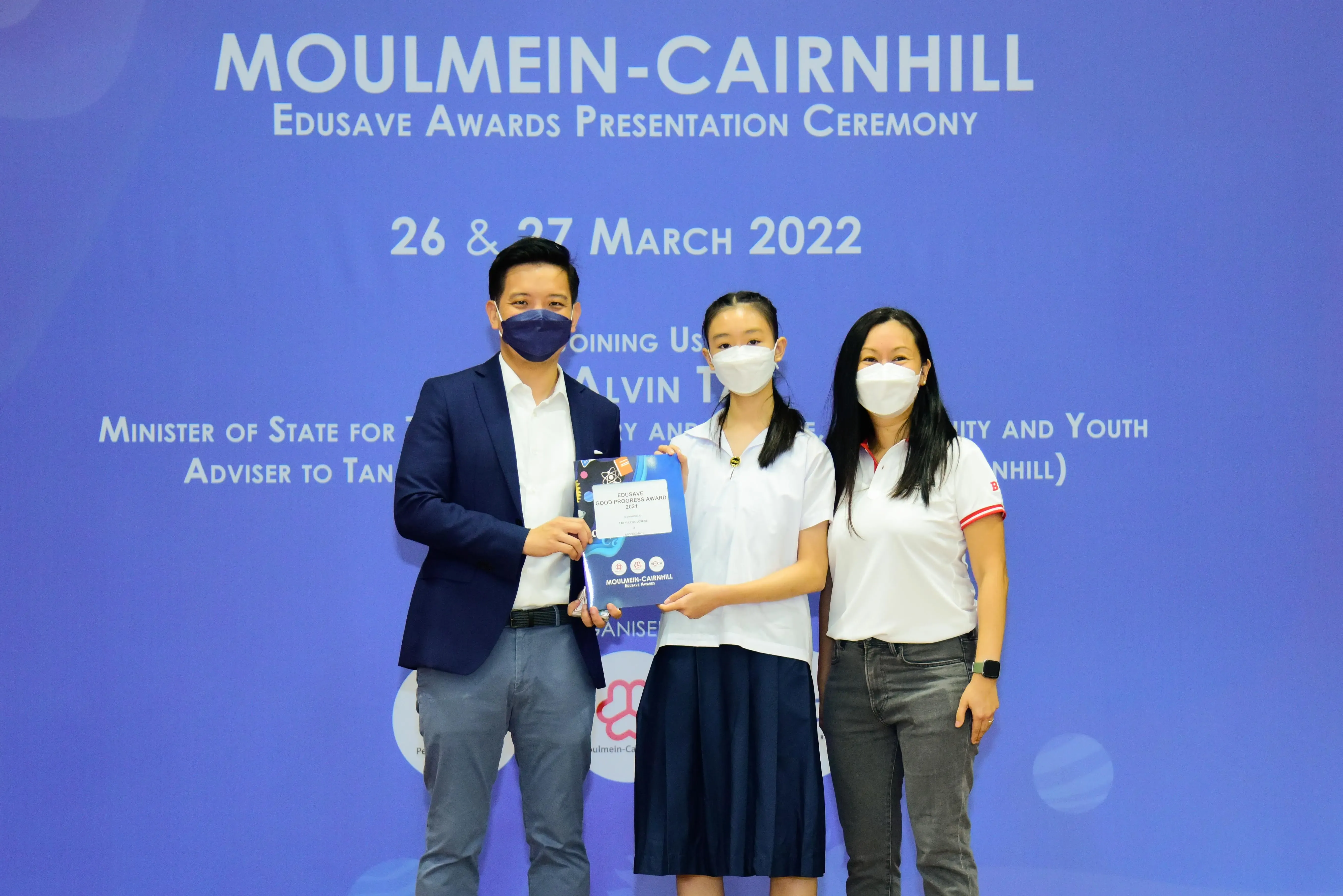 Three masked people pose at the Moulmein-Cairnhill Edusave Awards Presentation Ceremony on 26-27 March 2022.